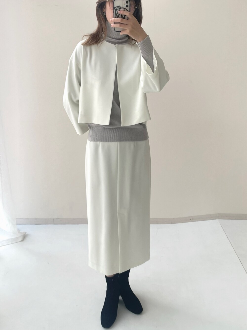 グレー系のニット/セーター、ベージュ系のスーツセットを着用したレディースの秋コーディネートの2枚目の写真