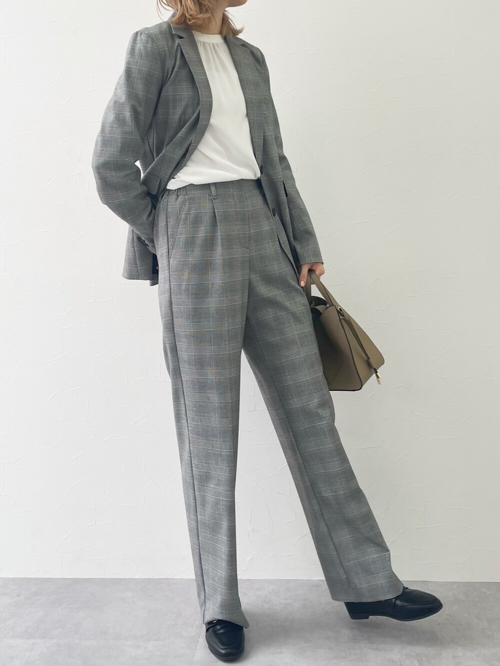 グレー系のパンツ、ブラック系のローファー、ホワイト系のシャツ/ブラウスを着用したレディースの冬コーディネートの2枚目の写真