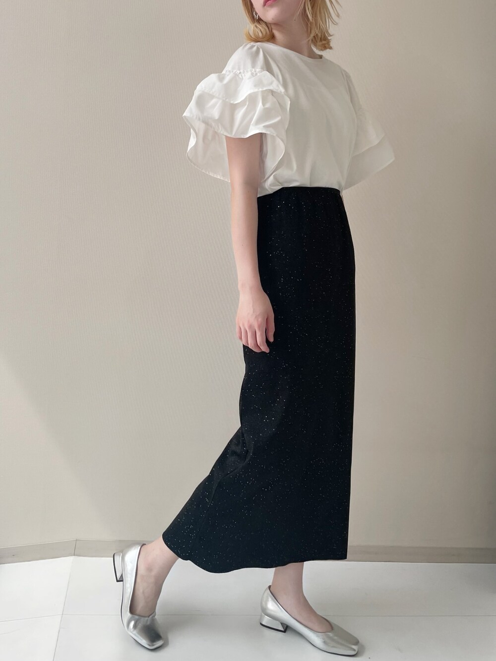 ホワイト系のTシャツ/カットソー、ブラック系のスカート、シルバー系のパンプスを着用したレディースの春コーディネートの2枚目の写真