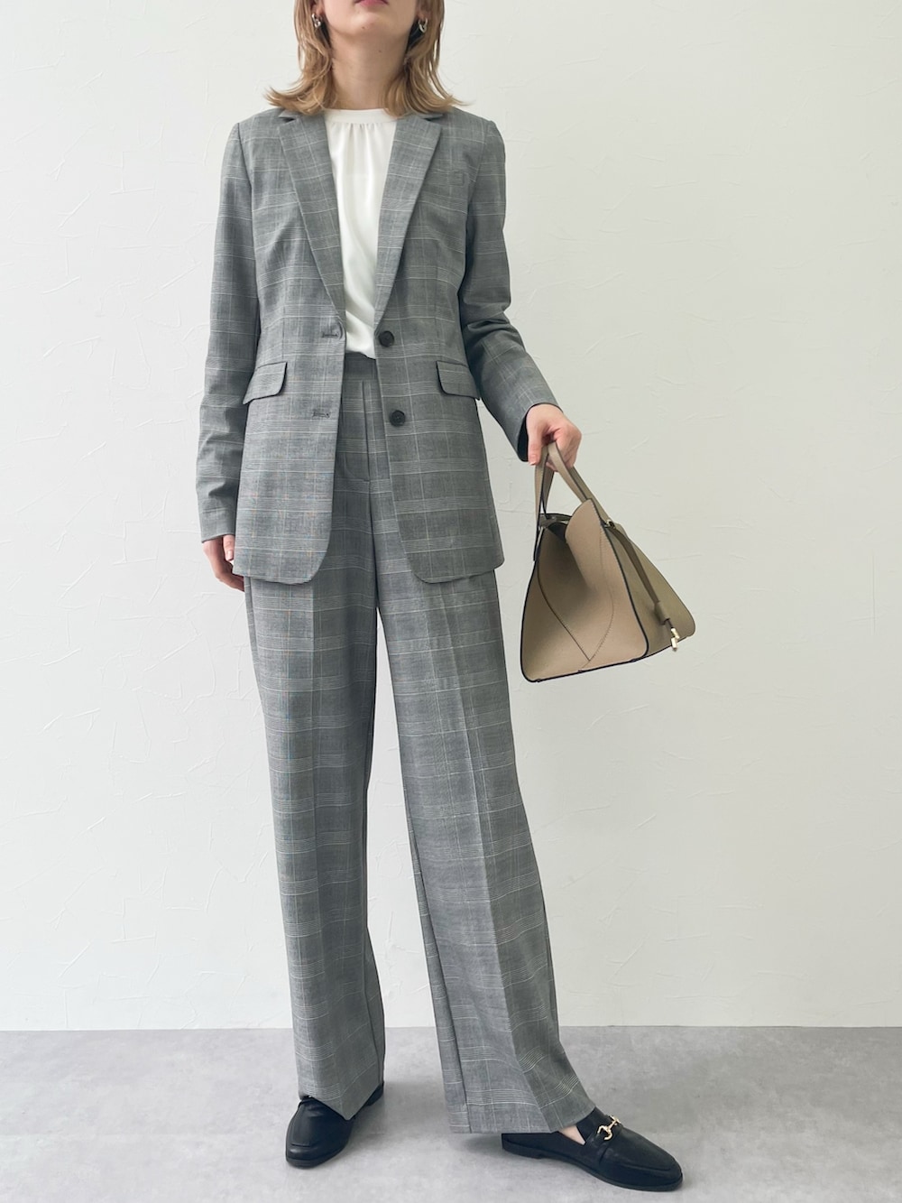 グレー系のパンツ、ブラック系のローファー、ホワイト系のシャツ/ブラウスを着用したレディースの冬コーディネートの3枚目の写真