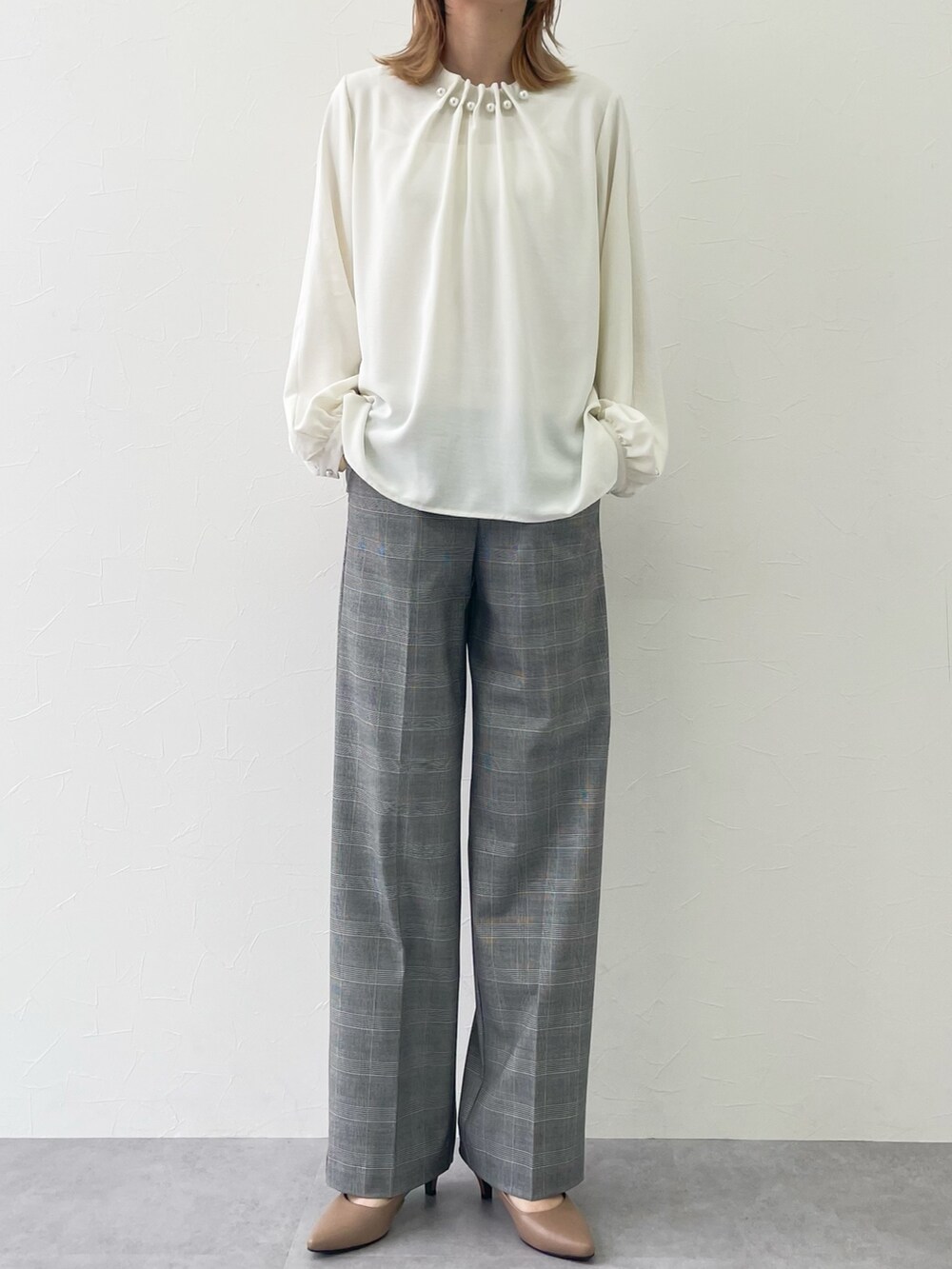ホワイト系のシャツ/ブラウス、グレー系のパンツを着用したレディースの春コーディネートの2枚目の写真