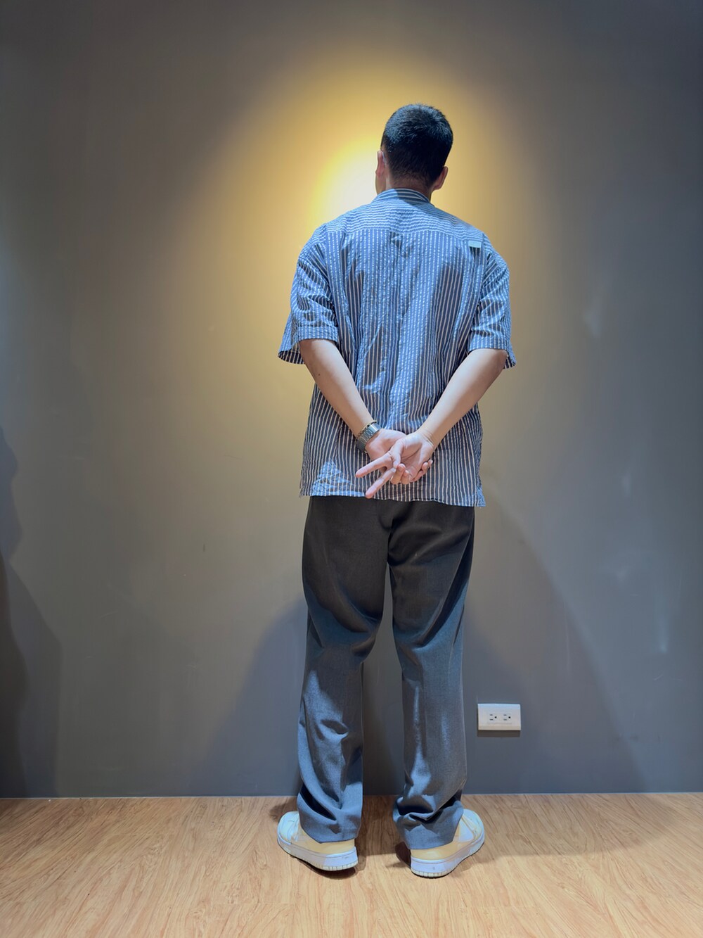 ブルー系のシャツ/ブラウス、グレー系のスラックス、ホワイト系のスニーカーを着用したメンズの秋コーディネートの2枚目の写真