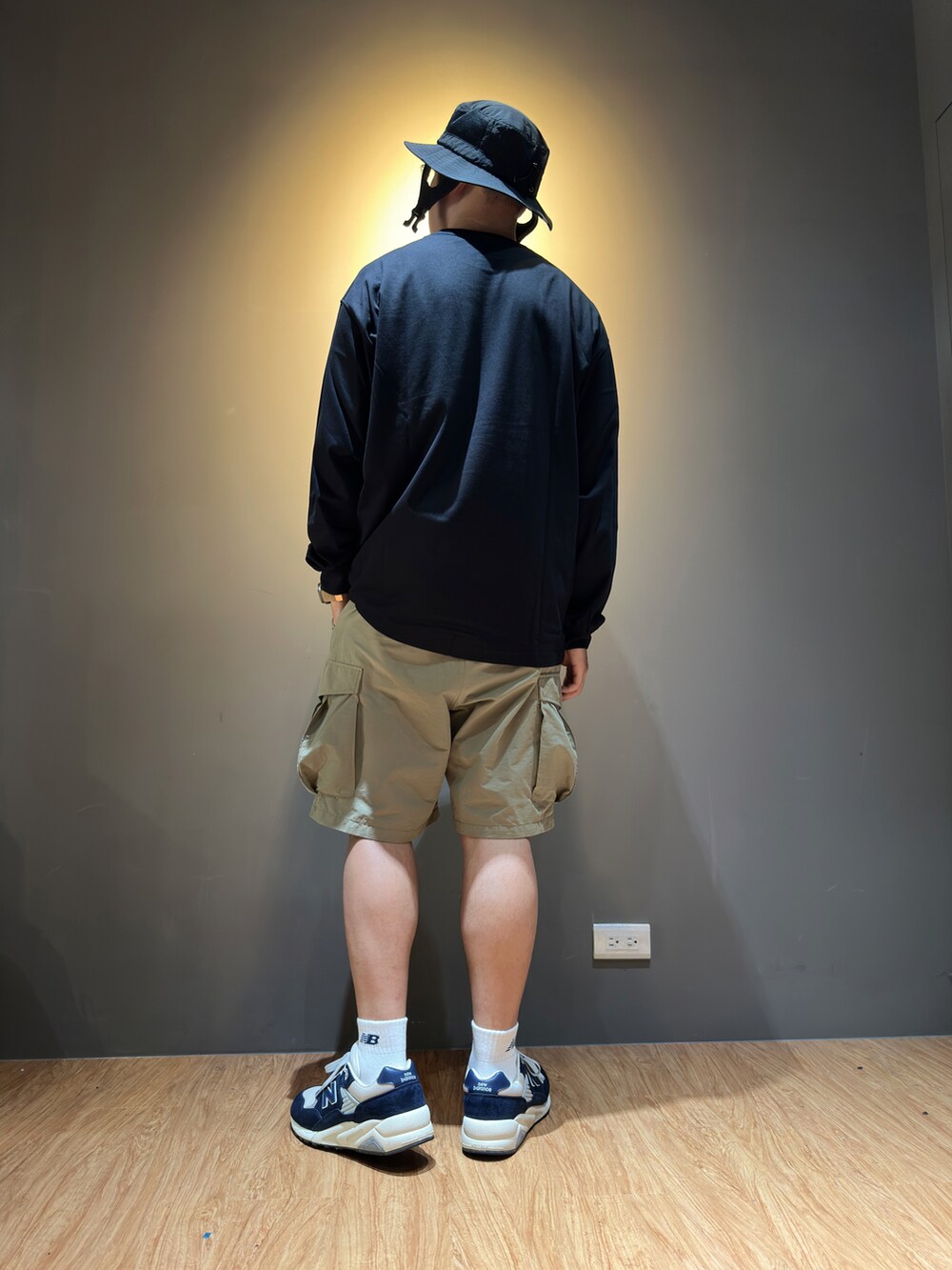 ブラック系のTシャツ/カットソー、ベージュ系のカーゴパンツ、ブルー系のスニーカーを着用したメンズの秋コーディネートの2枚目の写真