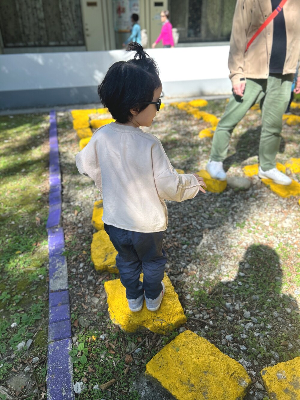 ブルー系のチノパンツ、グレー系のローファー、ブラック系のサングラスを着用したキッズの冬コーディネートの3枚目の写真