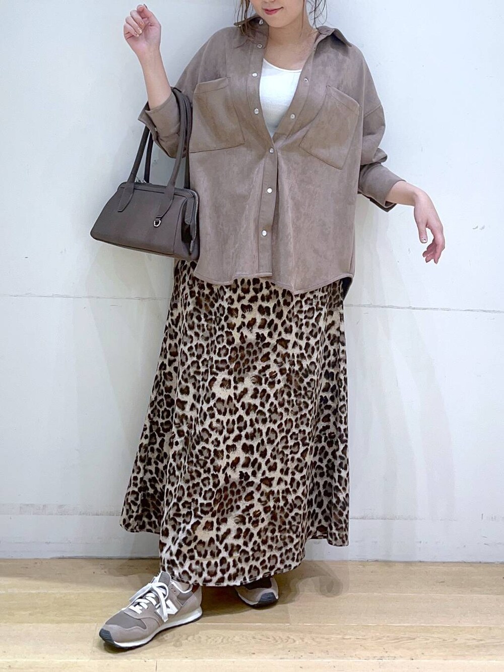 ホワイト系のタンクトップ、ブラウン系のスニーカー、ブラウン系のスカートを着用したレディースの秋コーディネートの3枚目の写真