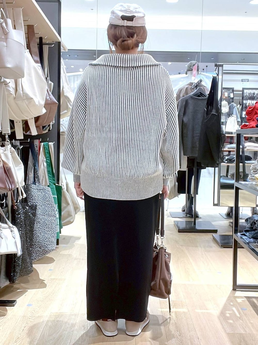 ブラウン系のスニーカー、ブラウン系のショルダーバッグ、ベージュ系のニット/セーターを着用したレディースの秋コーディネートの7枚目の写真