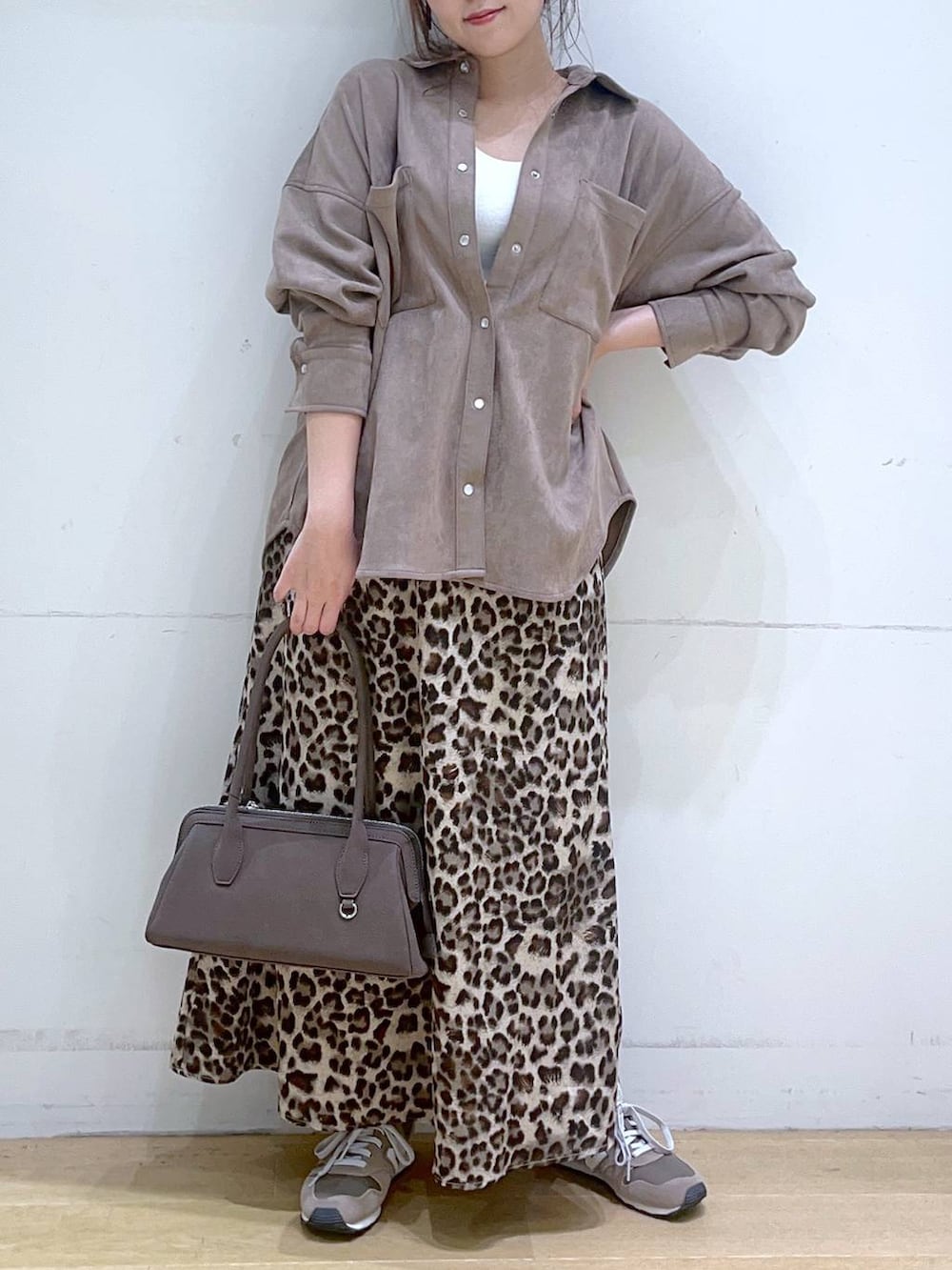 ホワイト系のタンクトップ、ブラウン系のスニーカー、ブラウン系のスカートを着用したレディースの秋コーディネートの2枚目の写真