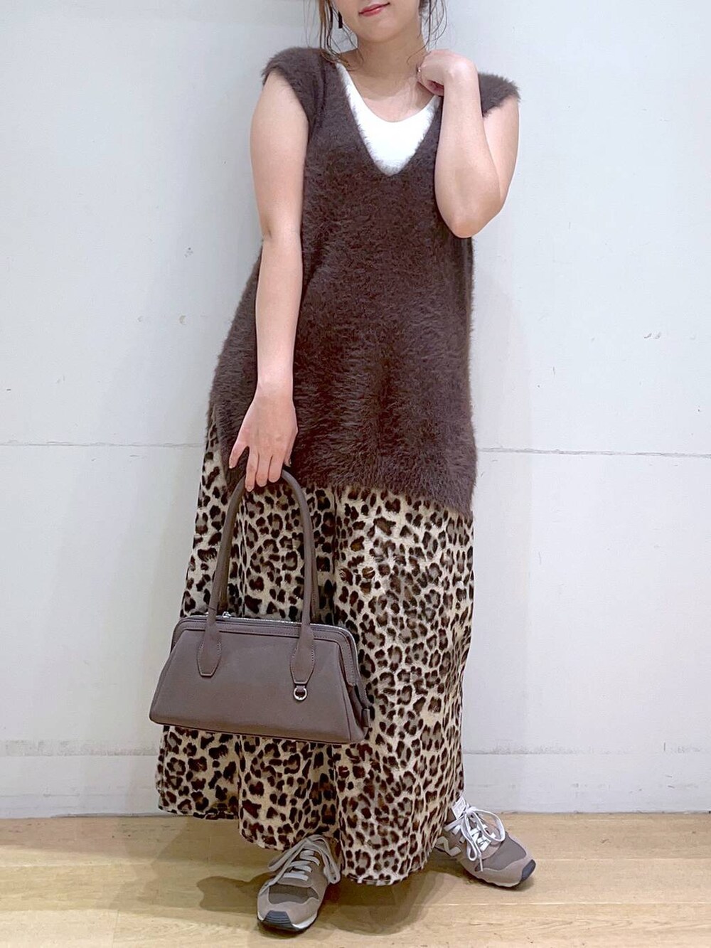 ホワイト系のタンクトップ、ブラウン系のスニーカー、ブラウン系のベストを着用したレディースの秋コーディネートの2枚目の写真