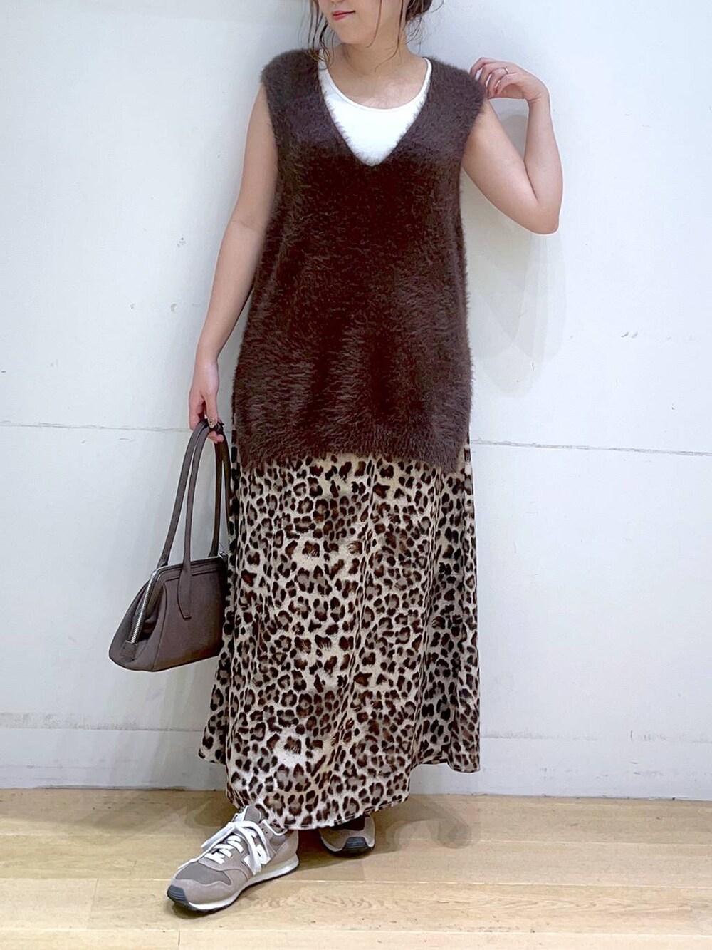 ホワイト系のタンクトップ、ブラウン系のスニーカー、ブラウン系のベストを着用したレディースの秋コーディネートの3枚目の写真