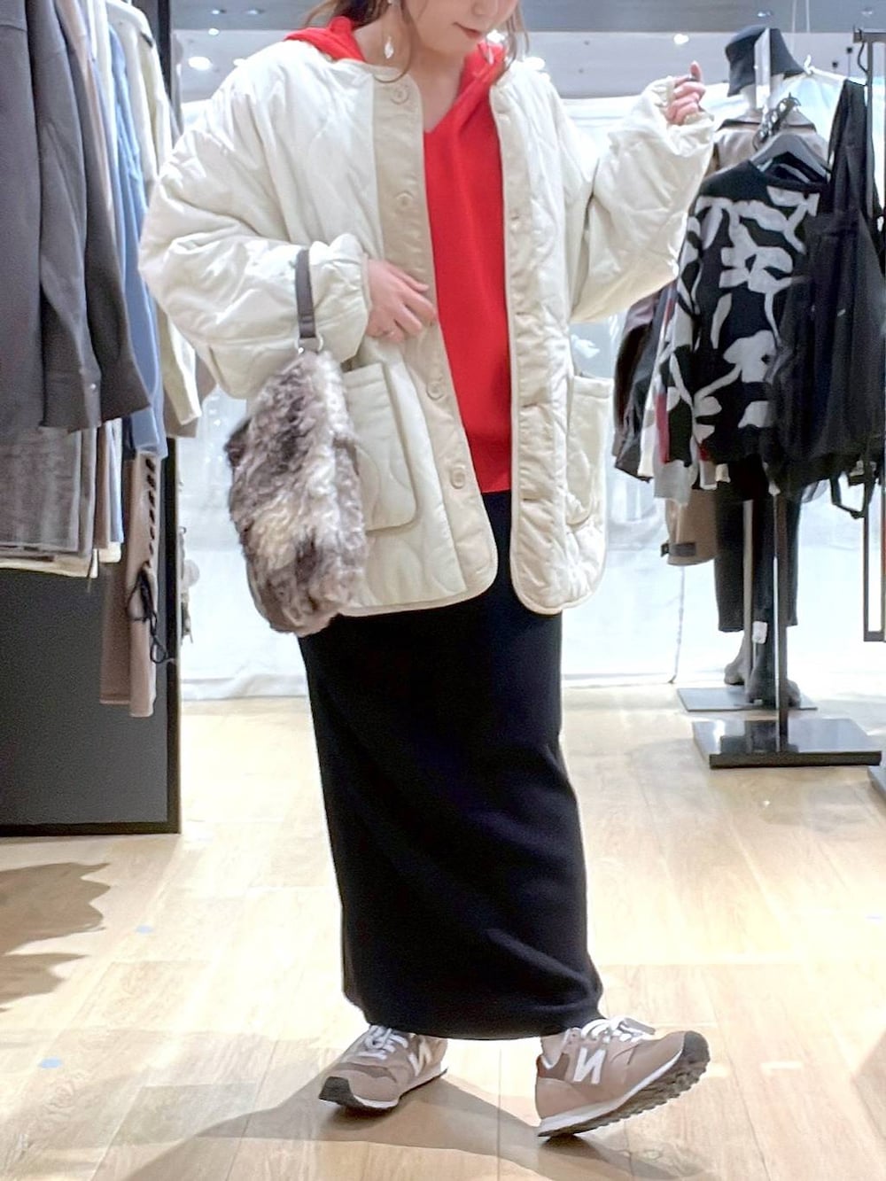 ブラウン系のスニーカー、ベージュ系のブルゾン、レッド系のニット/セーターを着用したレディースの秋コーディネートの2枚目の写真