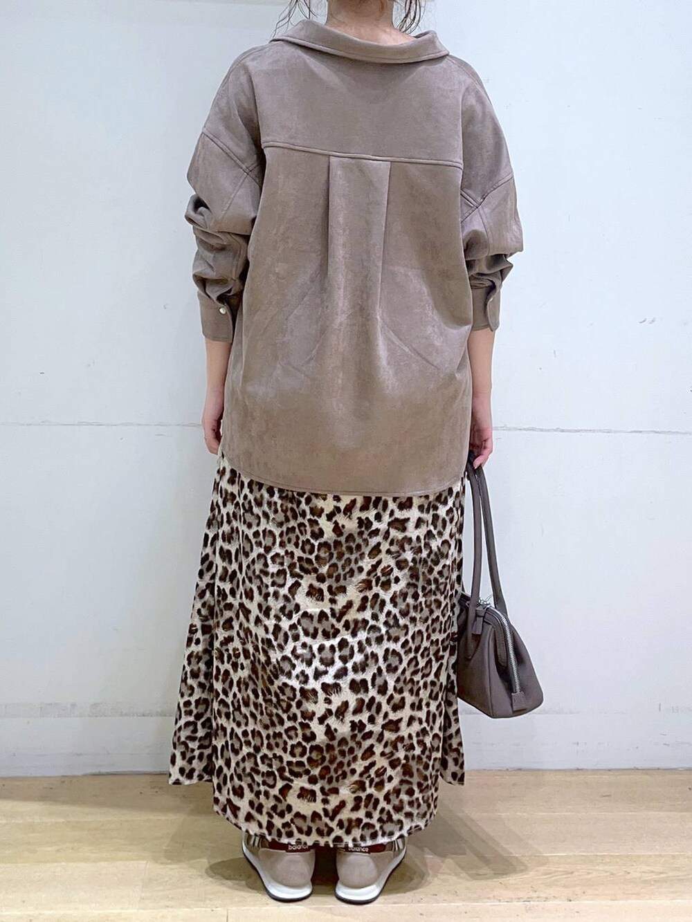 ホワイト系のタンクトップ、ブラウン系のスニーカー、ブラウン系のスカートを着用したレディースの秋コーディネートの6枚目の写真