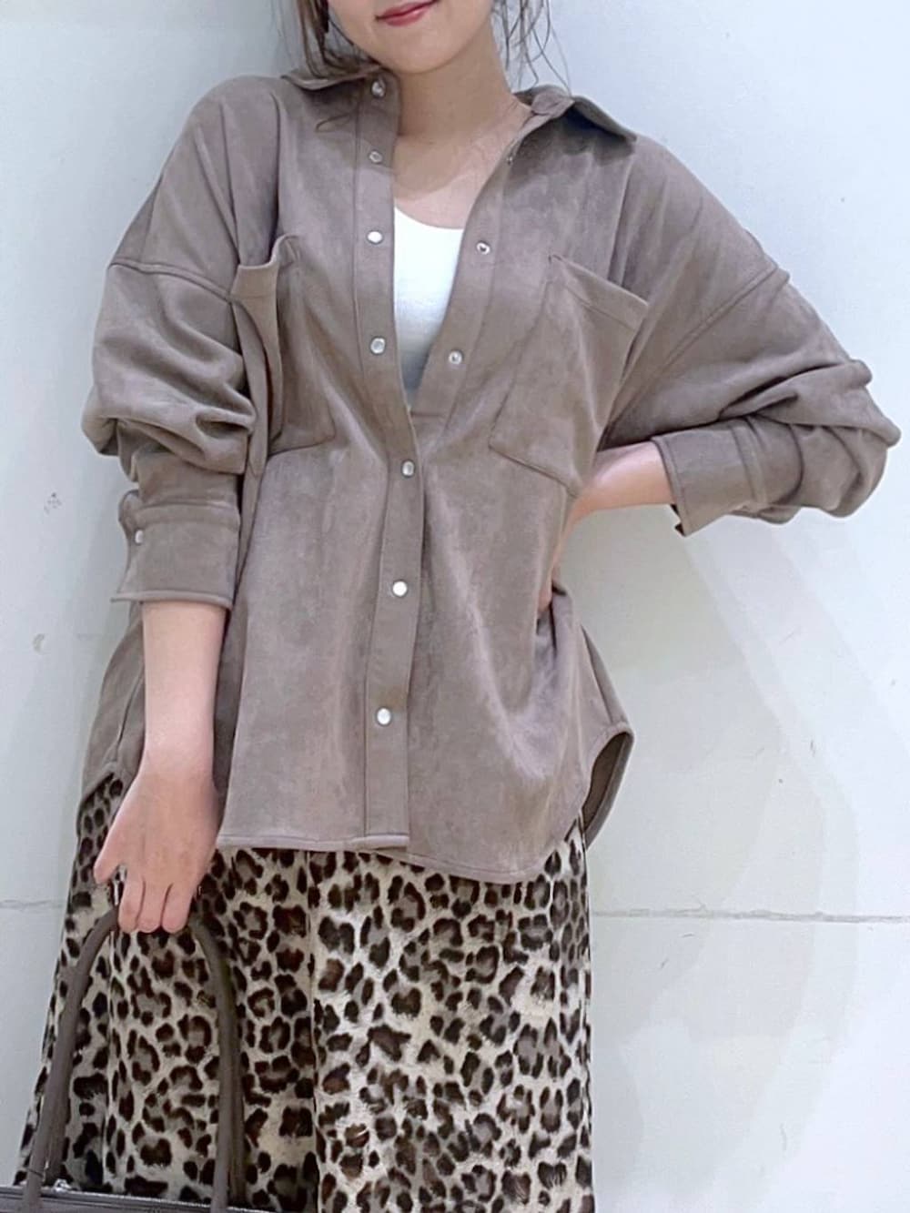 ホワイト系のタンクトップ、ブラウン系のスニーカー、ブラウン系のスカートを着用したレディースの秋コーディネートの7枚目の写真