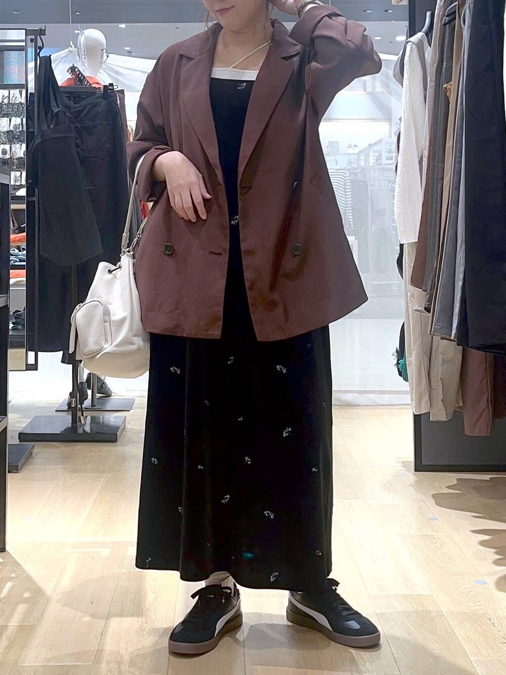 ベージュ系のキャミソール、ホワイト系のショルダーバッグ、レッド系のテーラードジャケットを着用したレディースの秋コーディネートの3枚目の写真