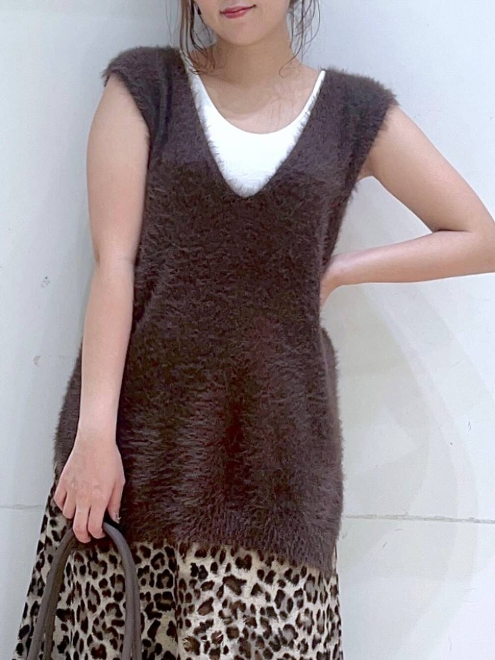 ホワイト系のタンクトップ、ブラウン系のスニーカー、ブラウン系のベストを着用したレディースの秋コーディネートの7枚目の写真