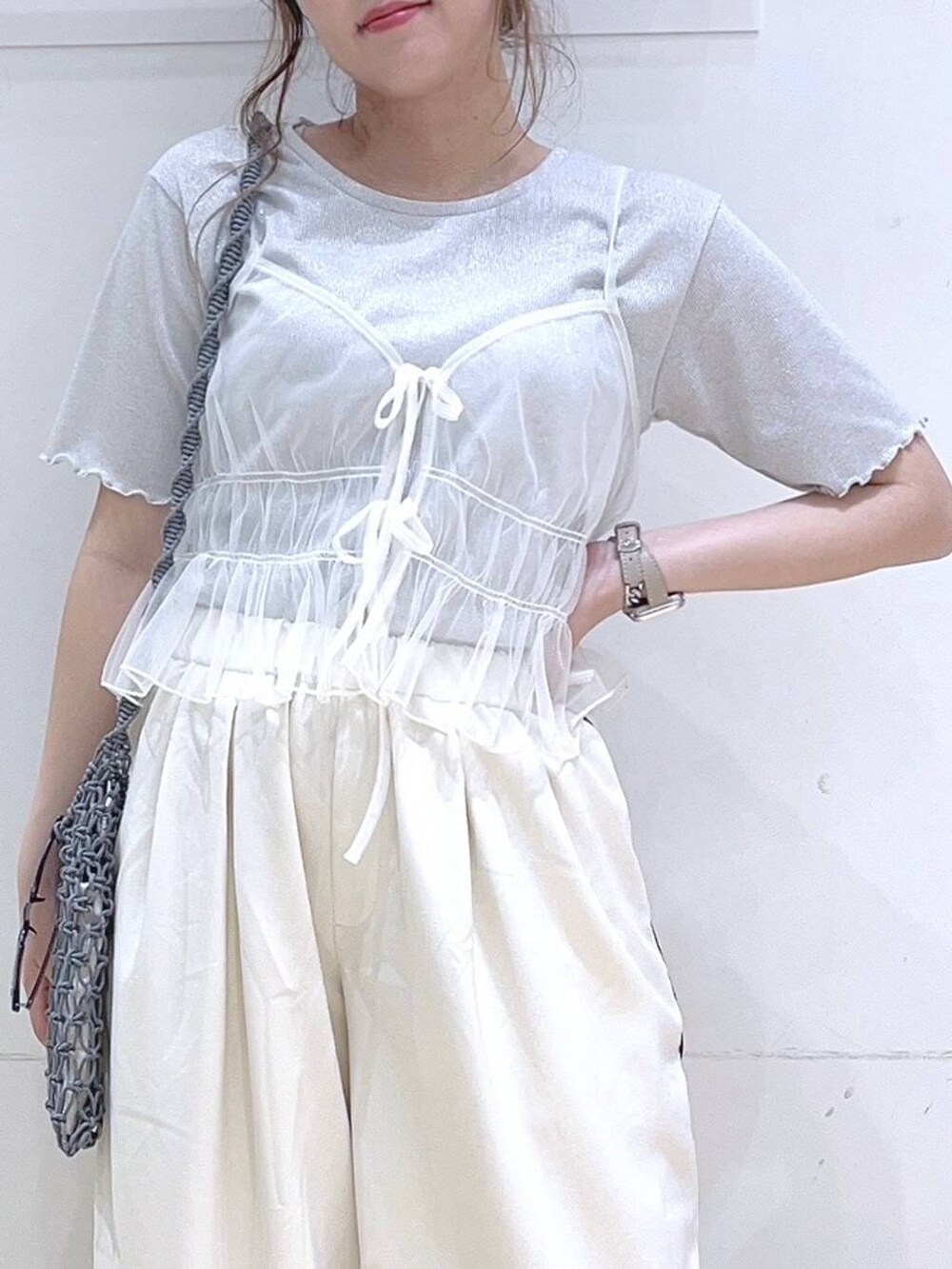 ホワイト系のサンダル、ホワイト系のキャミソール、グレー系のショルダーバッグを着用したレディースの夏コーディネートの6枚目の写真