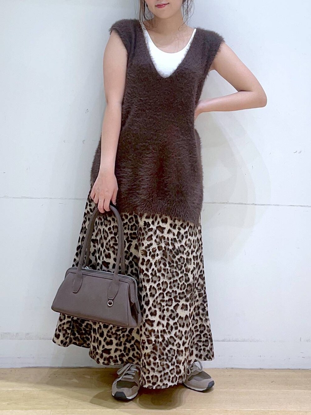 ホワイト系のタンクトップ、ブラウン系のスニーカー、ブラウン系のベストを着用したレディースの秋コーディネートの9枚目の写真