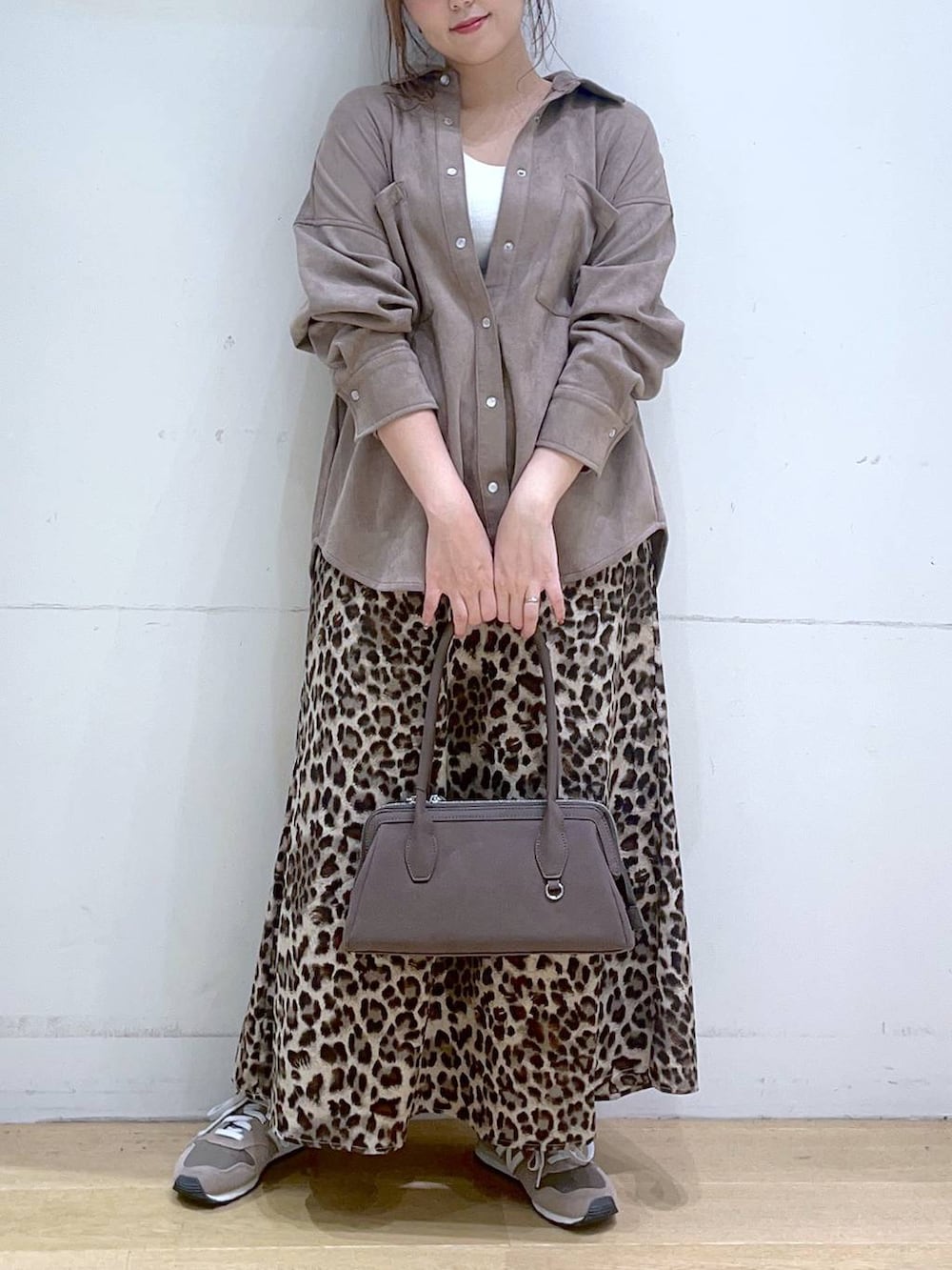 ホワイト系のタンクトップ、ブラウン系のスニーカー、ブラウン系のスカートを着用したレディースの秋コーディネートの4枚目の写真