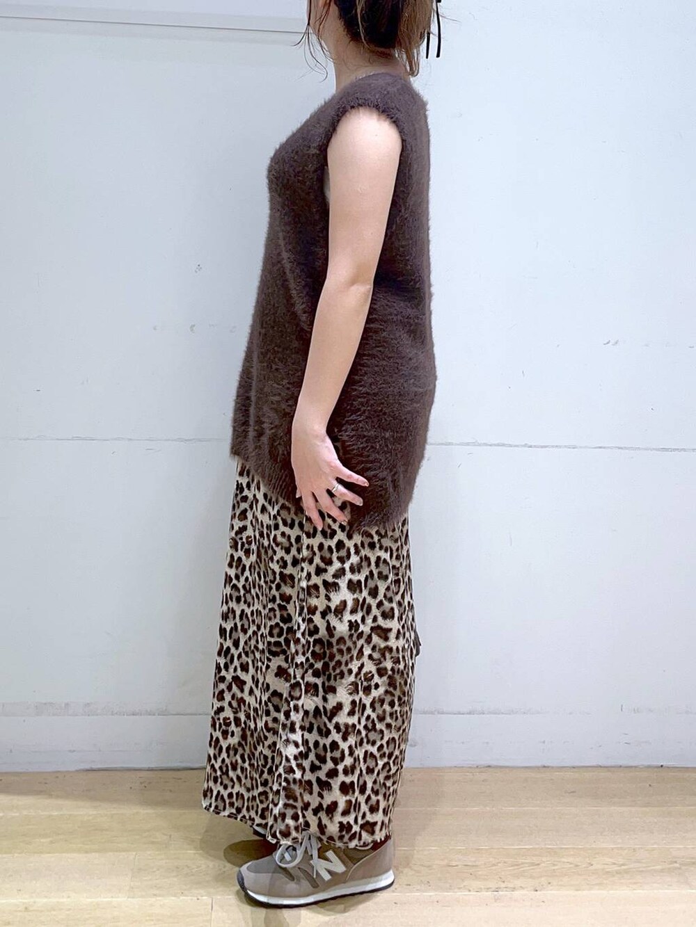 ホワイト系のタンクトップ、ブラウン系のスニーカー、ブラウン系のベストを着用したレディースの秋コーディネートの5枚目の写真