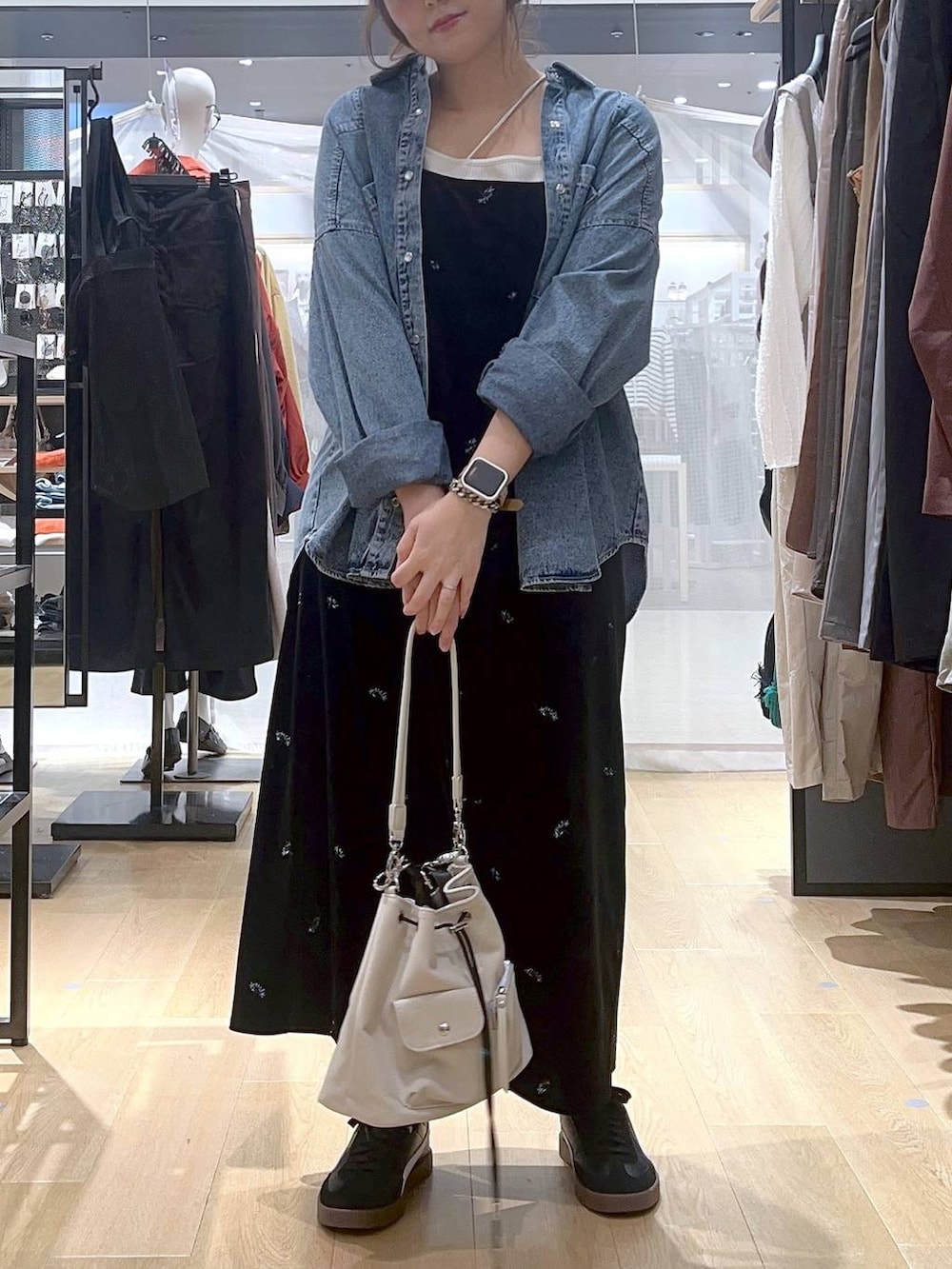 ブルー系のシャツ/ブラウス、ベージュ系のキャミソール、ホワイト系のショルダーバッグを着用したレディースの秋コーディネートの2枚目の写真