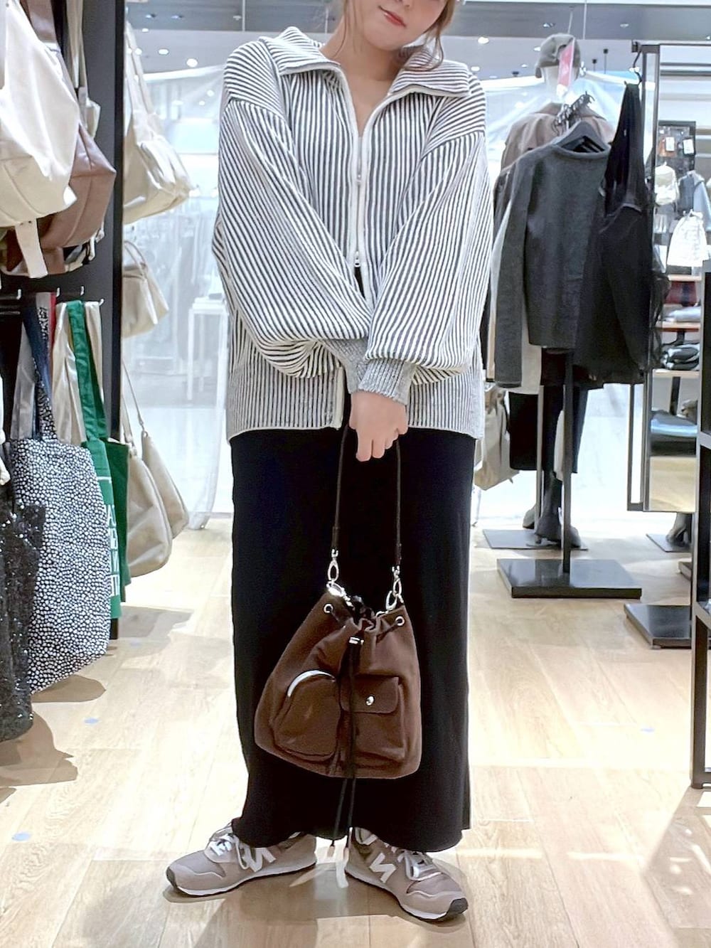 ブラウン系のスニーカー、ブラウン系のショルダーバッグ、ベージュ系のニット/セーターを着用したレディースの秋コーディネートの9枚目の写真