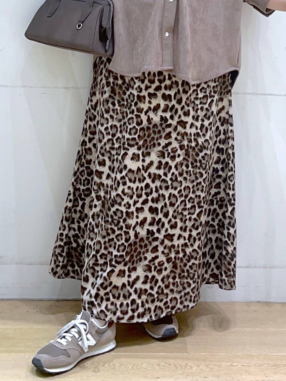 ホワイト系のタンクトップ、ブラウン系のスニーカー、ブラウン系のスカートを着用したレディースの秋コーディネートの8枚目の写真