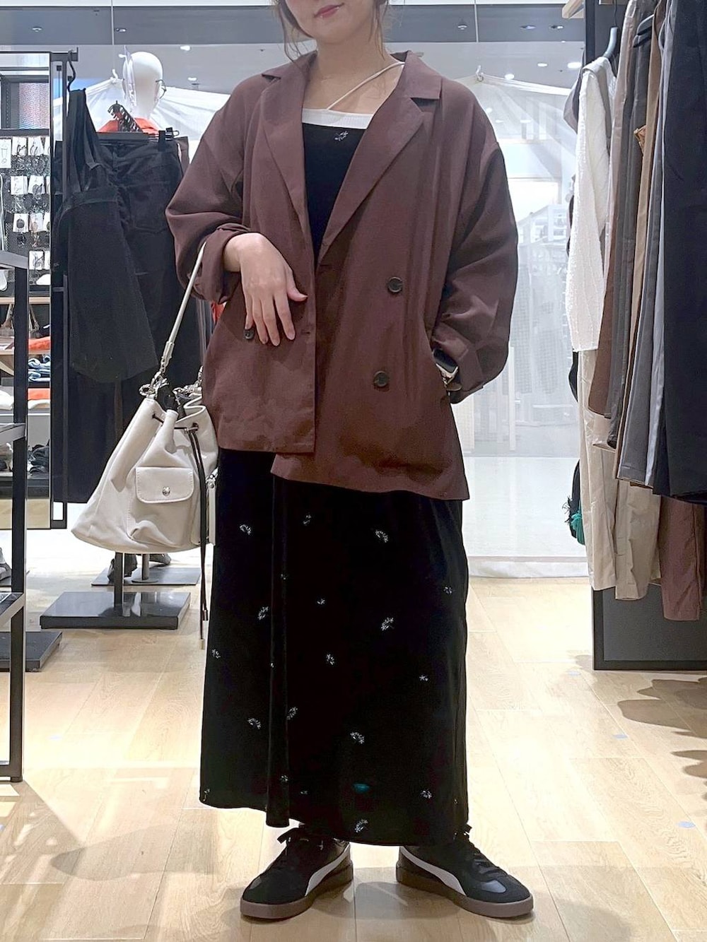 ベージュ系のキャミソール、ホワイト系のショルダーバッグ、レッド系のテーラードジャケットを着用したレディースの秋コーディネートの2枚目の写真