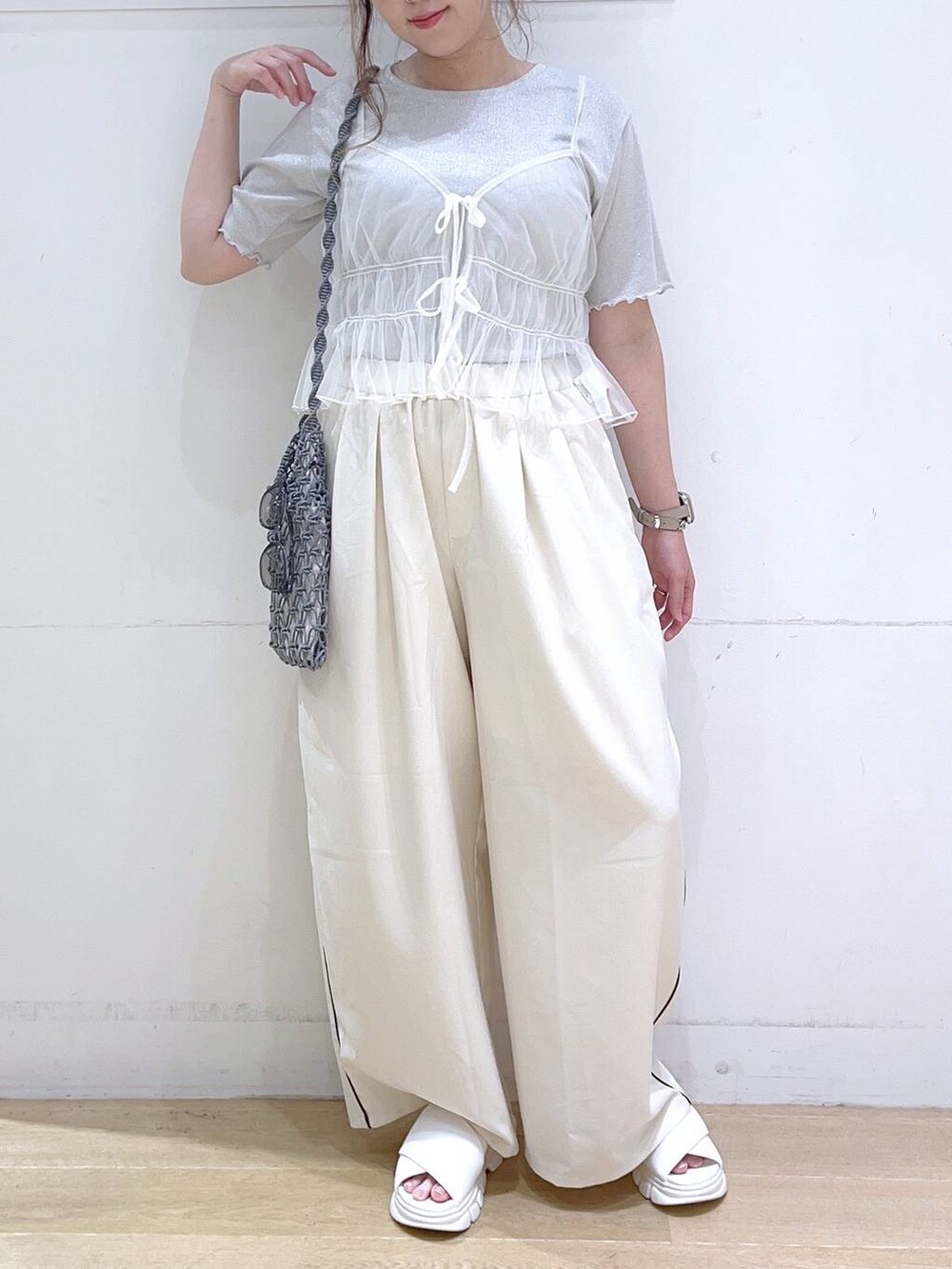 ホワイト系のサンダル、ホワイト系のキャミソール、グレー系のショルダーバッグを着用したレディースの夏コーディネートの3枚目の写真