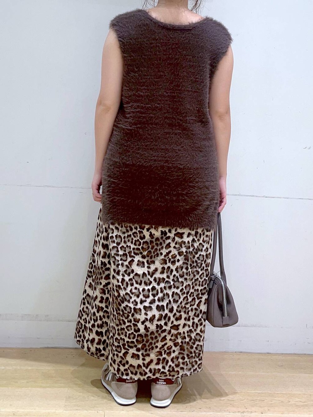 ホワイト系のタンクトップ、ブラウン系のスニーカー、ブラウン系のベストを着用したレディースの秋コーディネートの6枚目の写真