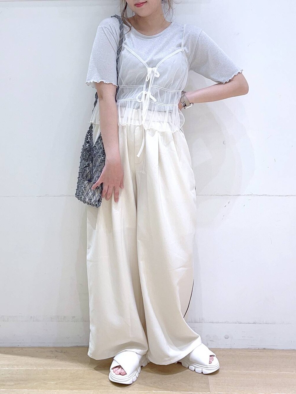 ホワイト系のサンダル、ホワイト系のキャミソール、グレー系のショルダーバッグを着用したレディースの夏コーディネートの2枚目の写真