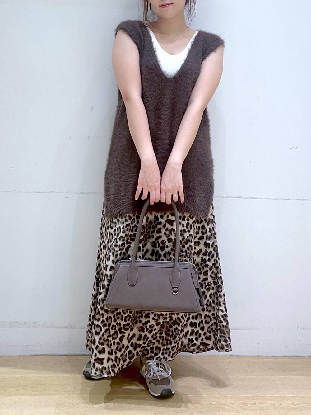 ホワイト系のタンクトップ、ブラウン系のスニーカー、ブラウン系のベストを着用したレディースの秋コーディネートの4枚目の写真