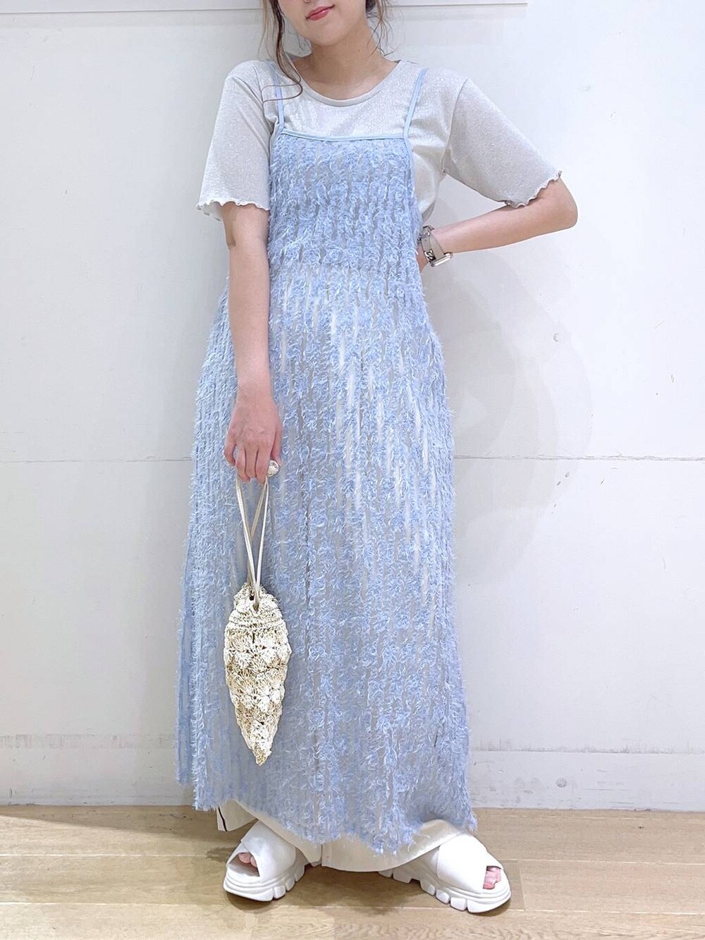 ホワイト系のサンダル、ブルー系のワンピース、ベージュ系のショルダーバッグを着用したレディースの春コーディネートの2枚目の写真