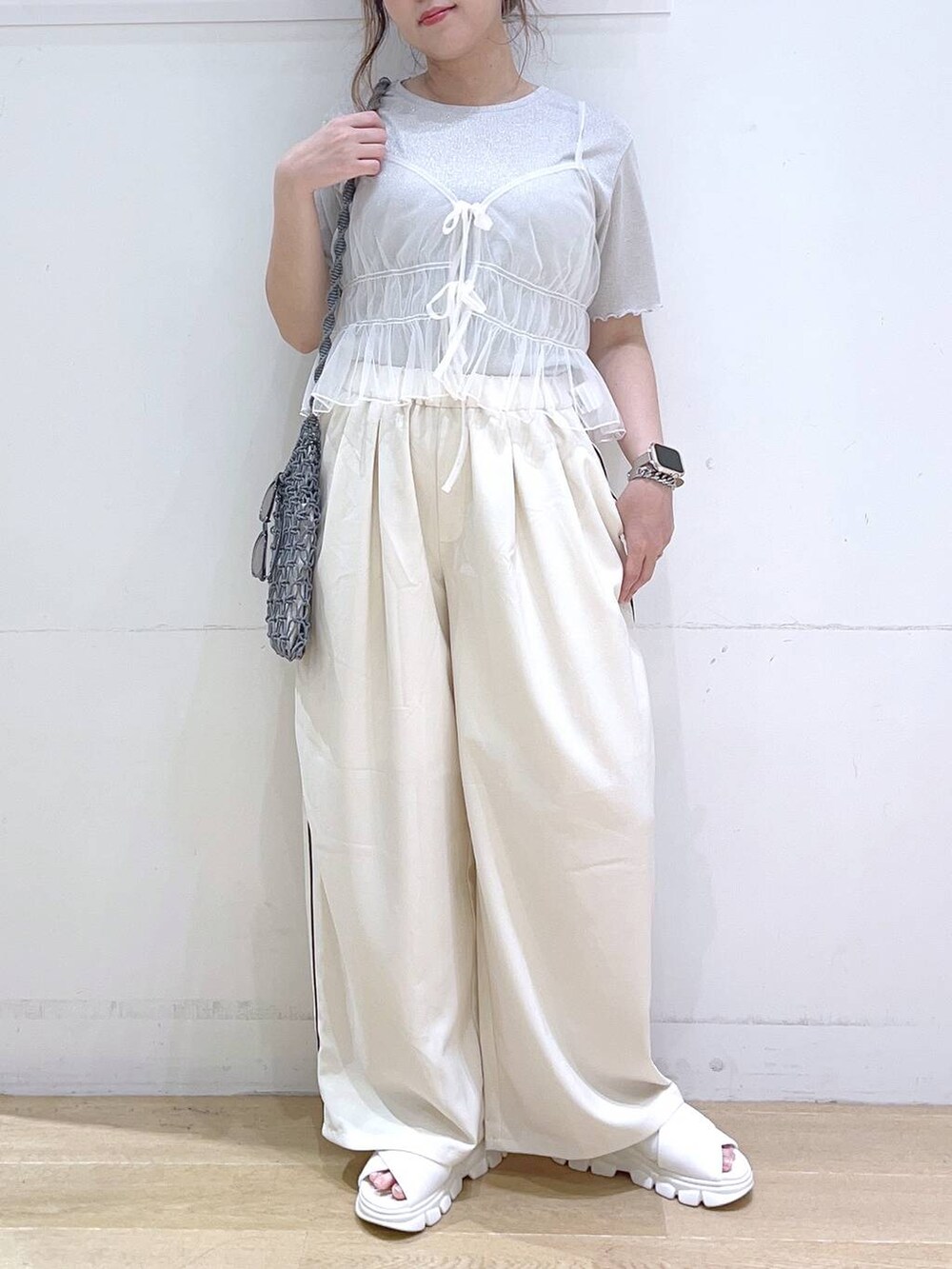 ホワイト系のサンダル、ホワイト系のキャミソール、グレー系のショルダーバッグを着用したレディースの夏コーディネートの4枚目の写真