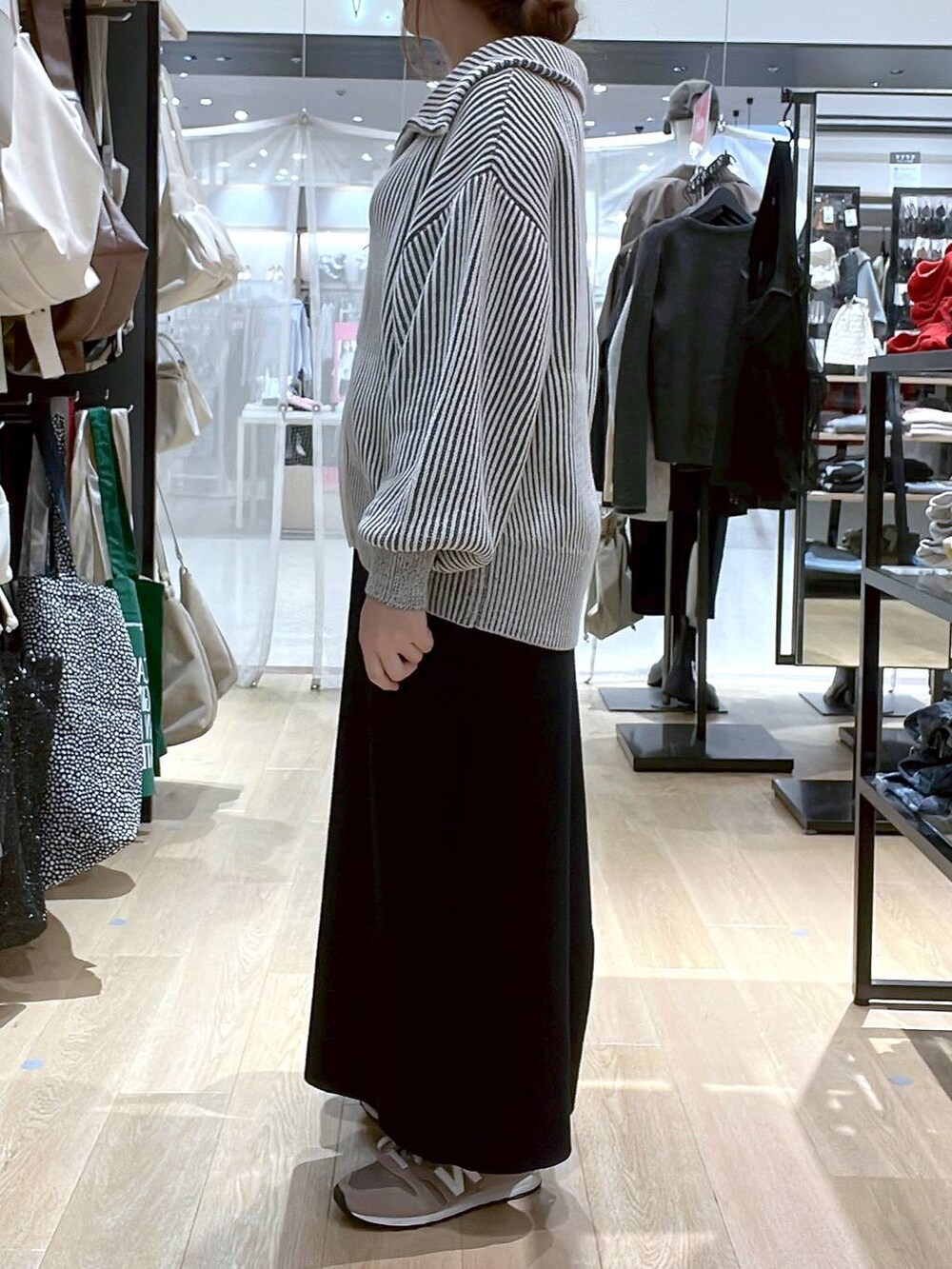 ブラウン系のスニーカー、ブラウン系のショルダーバッグ、ベージュ系のニット/セーターを着用したレディースの秋コーディネートの6枚目の写真