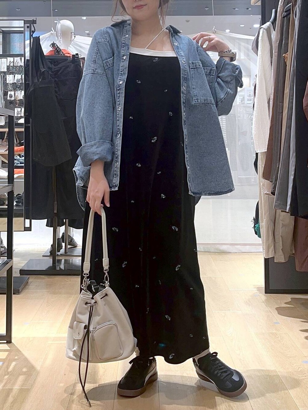 ブルー系のシャツ/ブラウス、ベージュ系のキャミソール、ホワイト系のショルダーバッグを着用したレディースの秋コーディネートの3枚目の写真