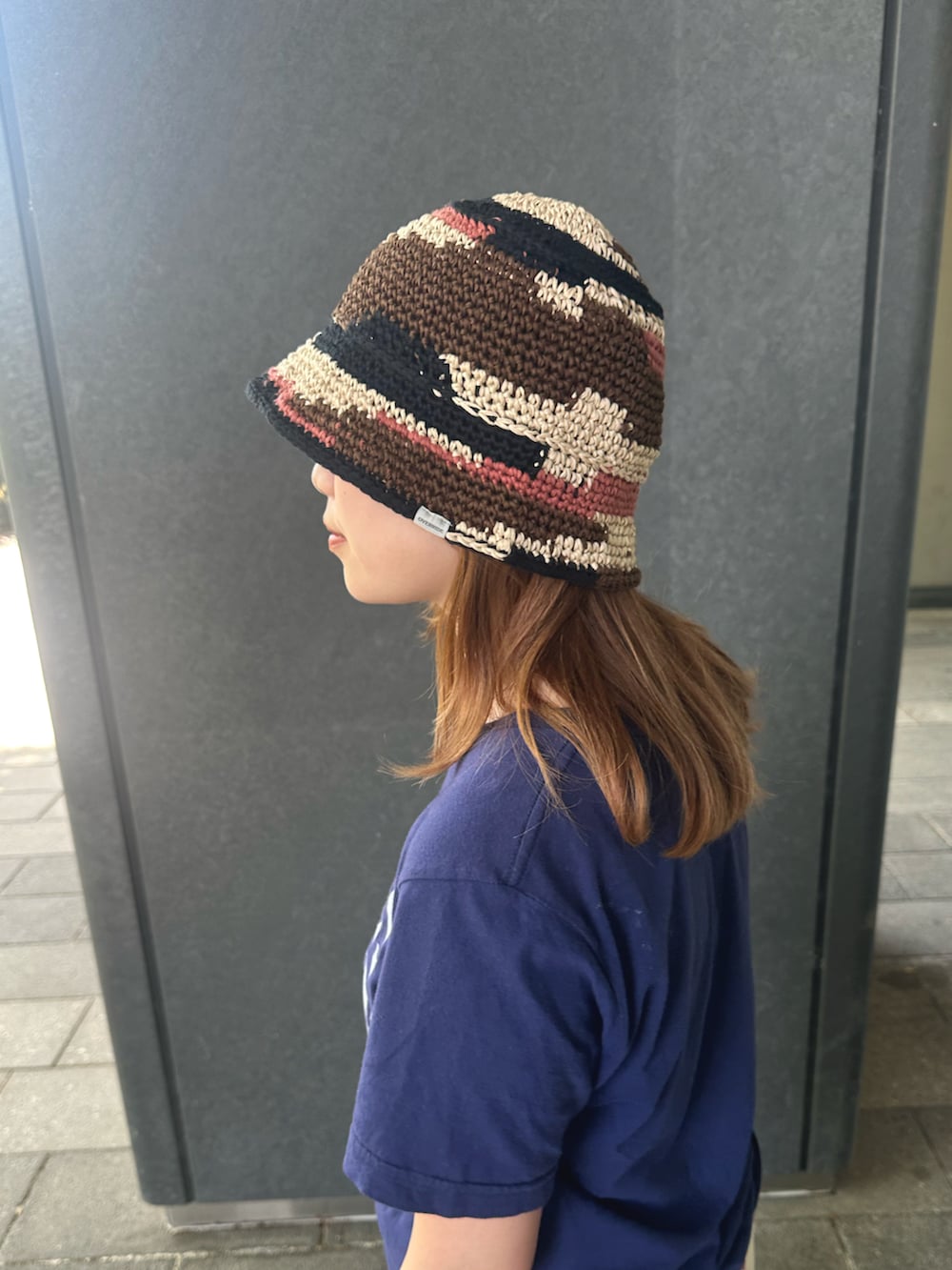 ブルー系のTシャツ/カットソー、ブラウン系のハットを着用したレディースの春コーディネートの2枚目の写真