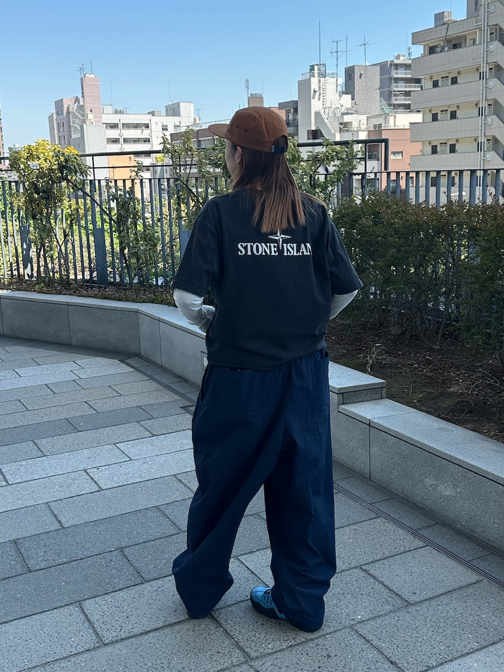 ブラック系のTシャツ/カットソー、ブルー系のその他パンツ、ブルー系のシューズを着用したレディースの春コーディネートの2枚目の写真