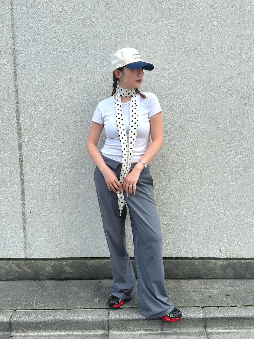 ホワイト系のTシャツ/カットソー、グレー系のスラックス、ブラック系のスニーカーを着用したレディースの夏コーディネートの2枚目の写真