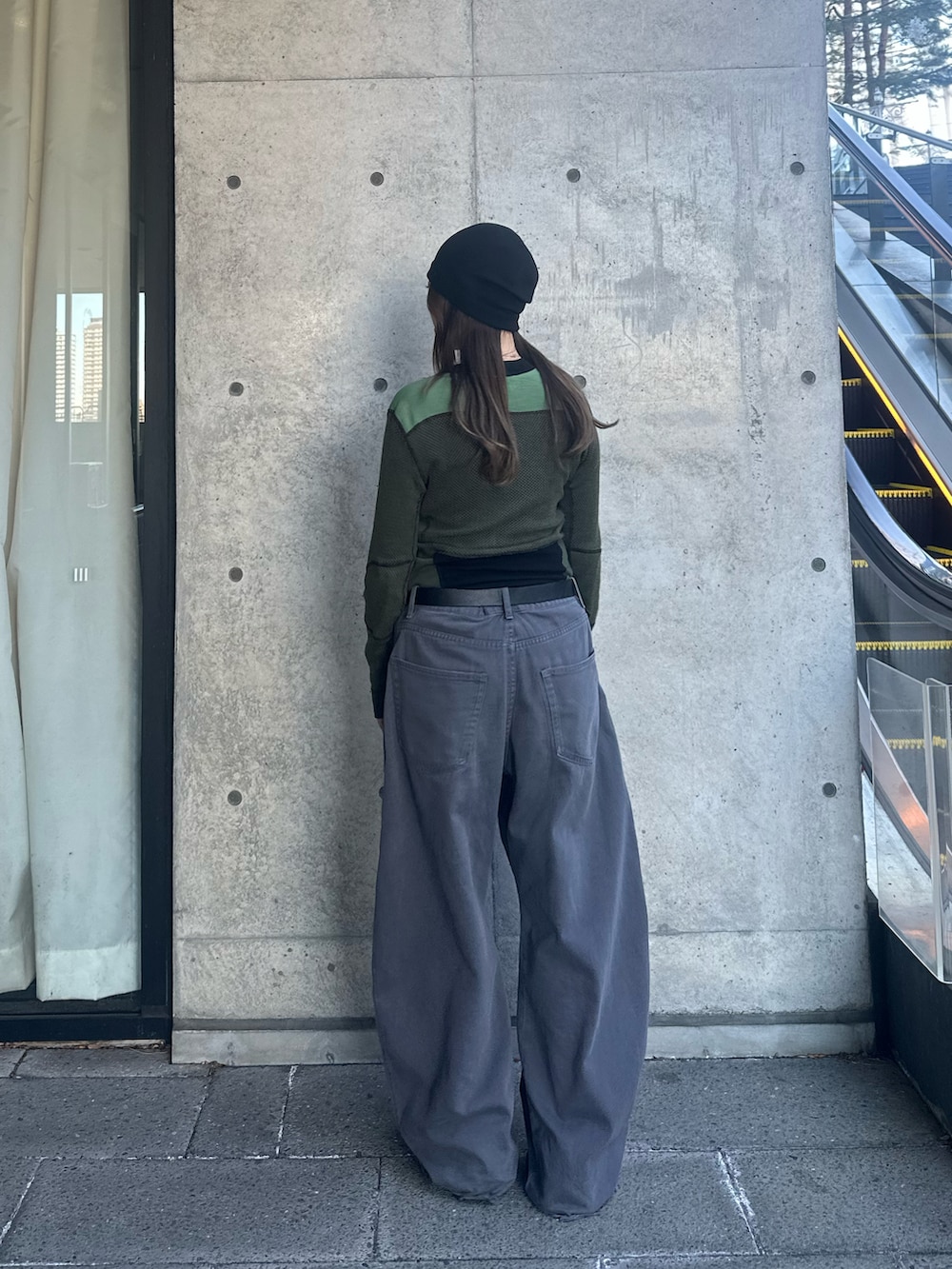 ブラック系のニットキャップ/ビーニーを着用したレディースの冬コーディネートの2枚目の写真