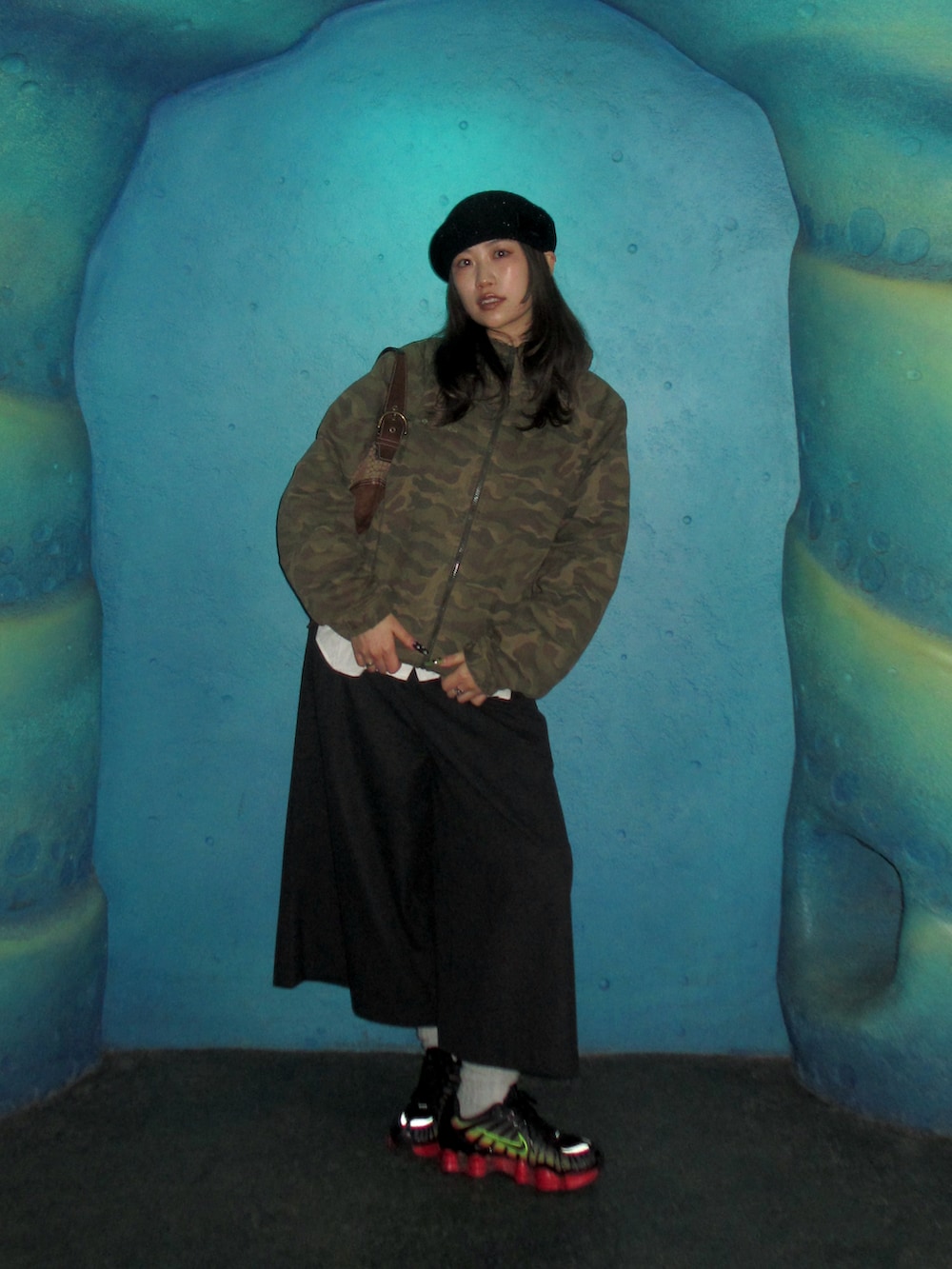 グレー系のパンツ、ブラック系のスニーカー、ブラック系のハンチング/ベレー帽を着用したレディースの冬コーディネートの2枚目の写真