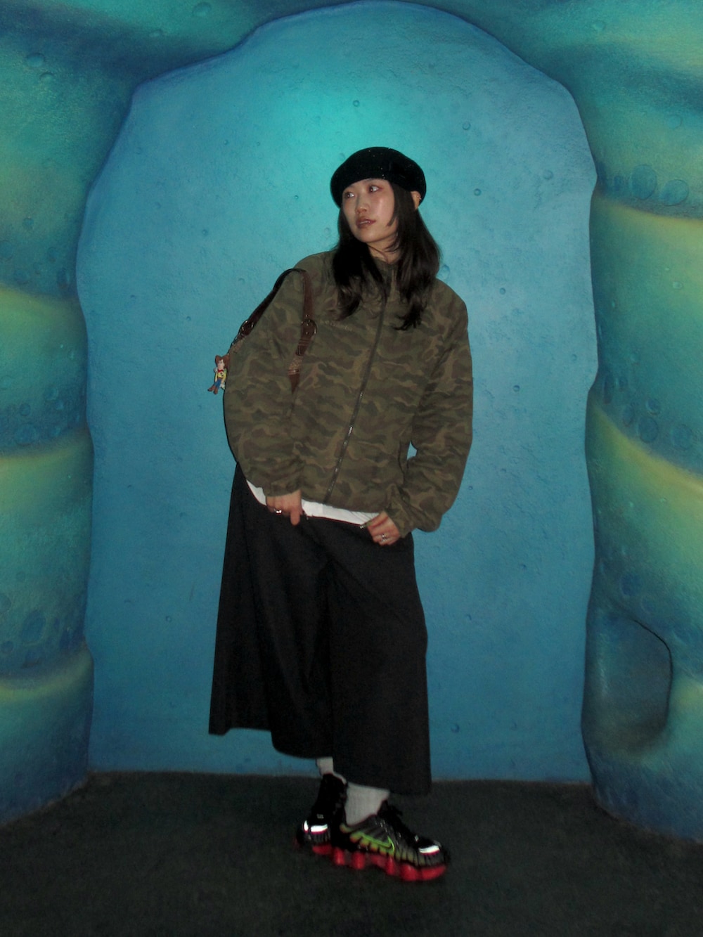 グレー系のパンツ、ブラック系のスニーカー、ブラック系のハンチング/ベレー帽を着用したレディースの冬コーディネートの3枚目の写真