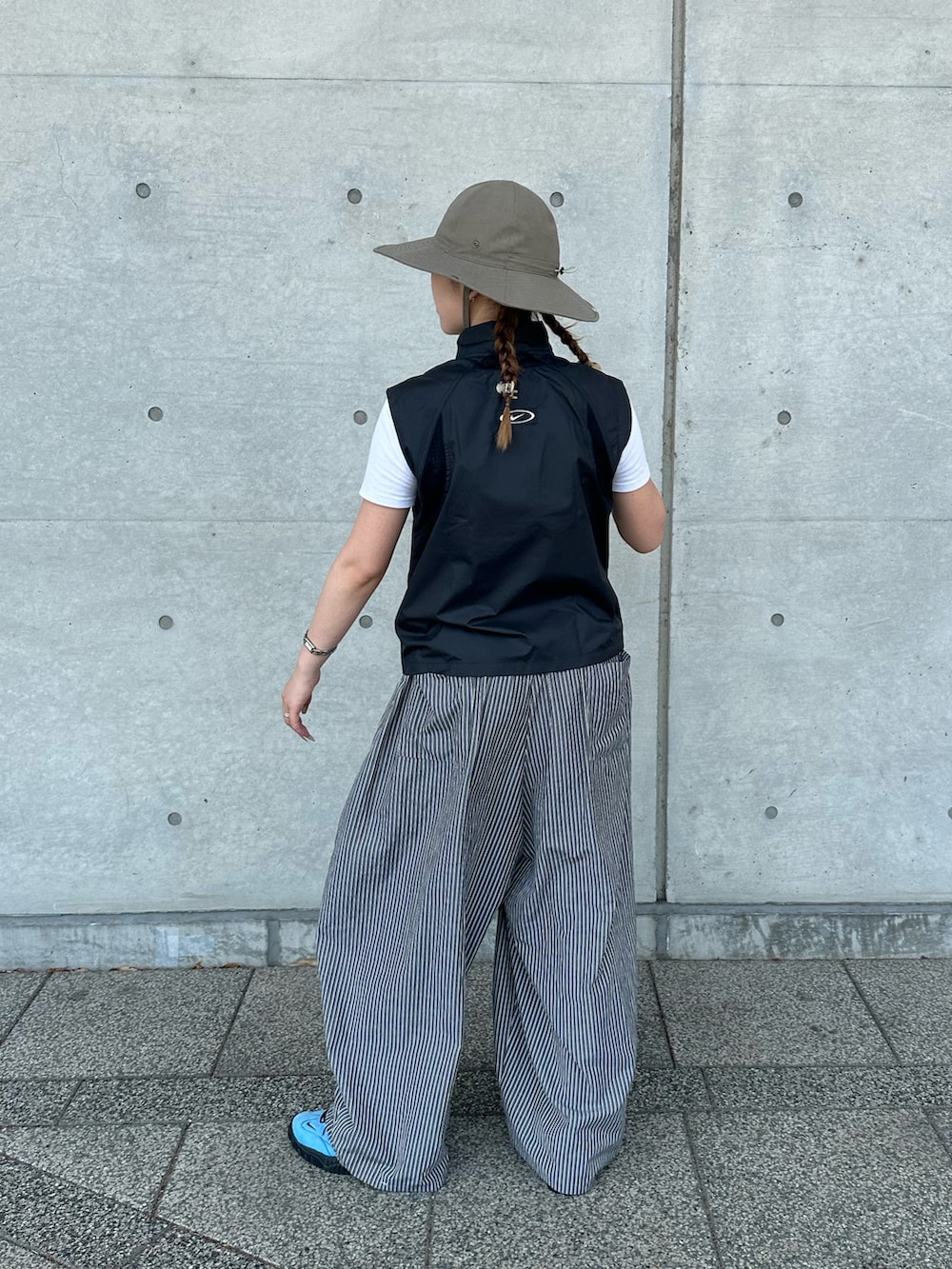 ブラック系のその他アウター、ブルー系のシューズ、ブラウン系のハットを着用したレディースの夏コーディネートの2枚目の写真