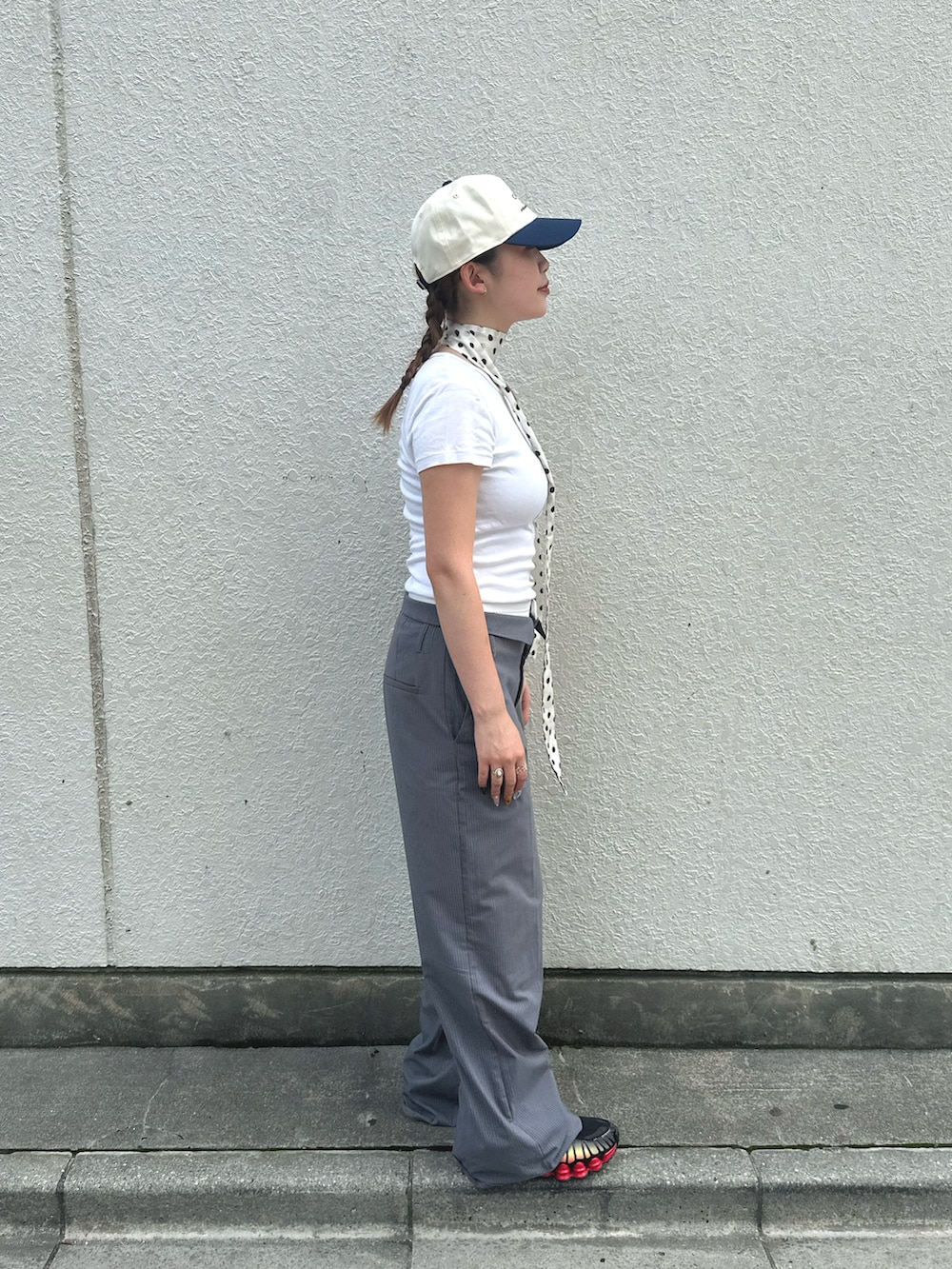 ホワイト系のTシャツ/カットソー、グレー系のスラックス、ブラック系のスニーカーを着用したレディースの夏コーディネートの3枚目の写真