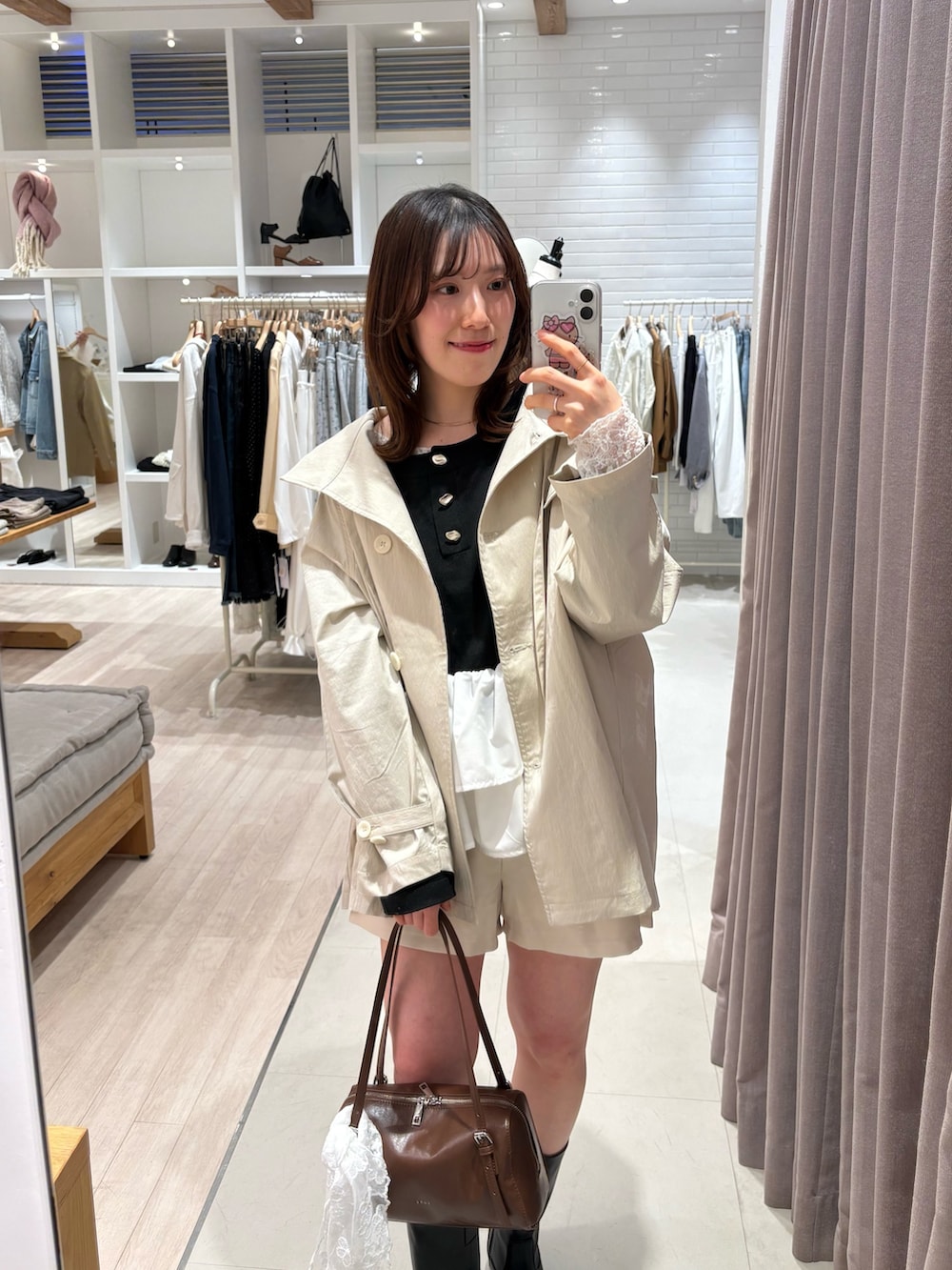 ホワイト系のトレンチコート、ホワイト系のその他パンツ、イエロー系のボストンバッグを着用したレディースの春コーディネートの3枚目の写真