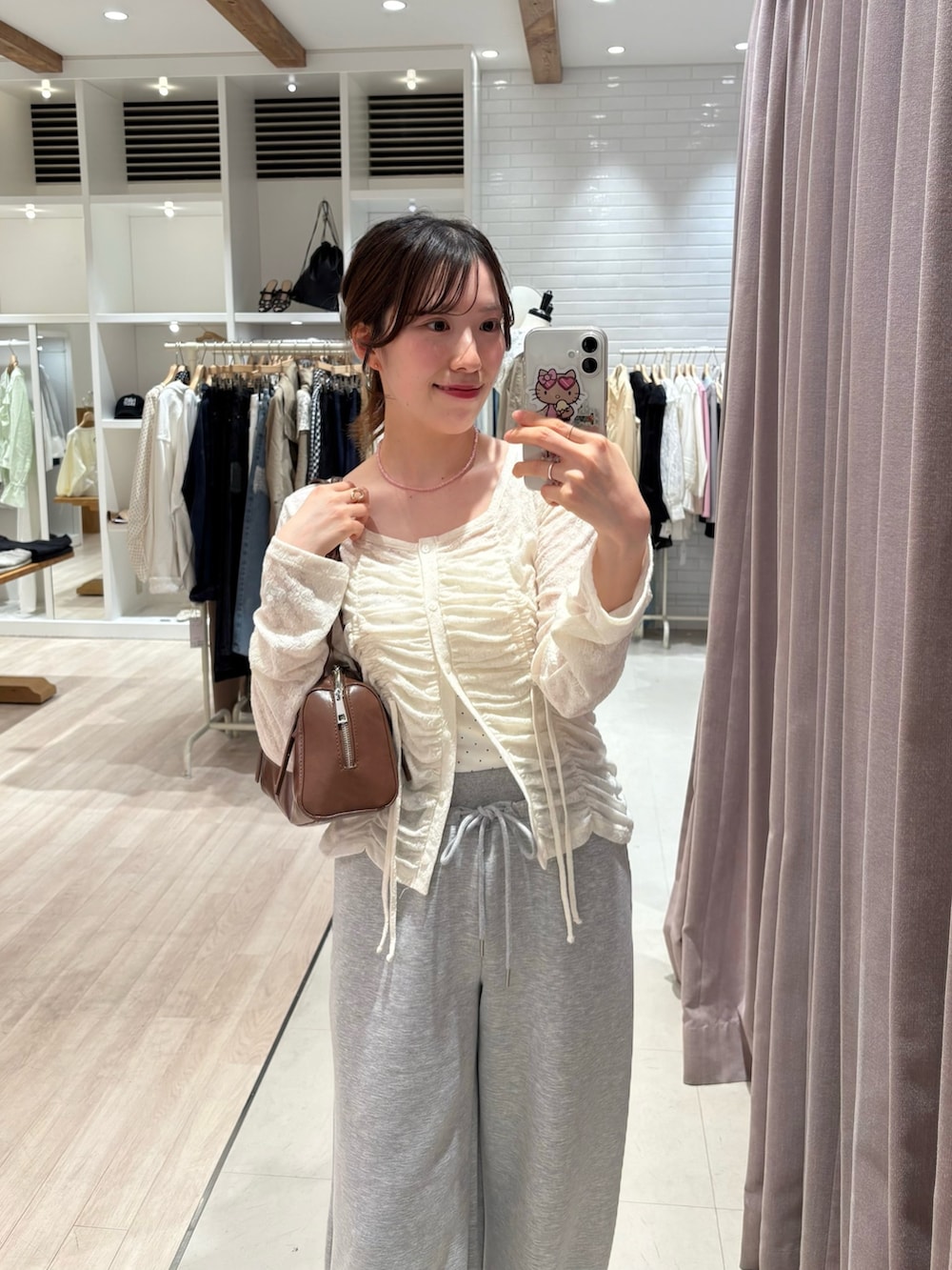 ホワイト系のカーディガン/ボレロ、ホワイト系のキャミソール、グレー系のスウェットパンツを着用したレディースの春コーディネートの2枚目の写真