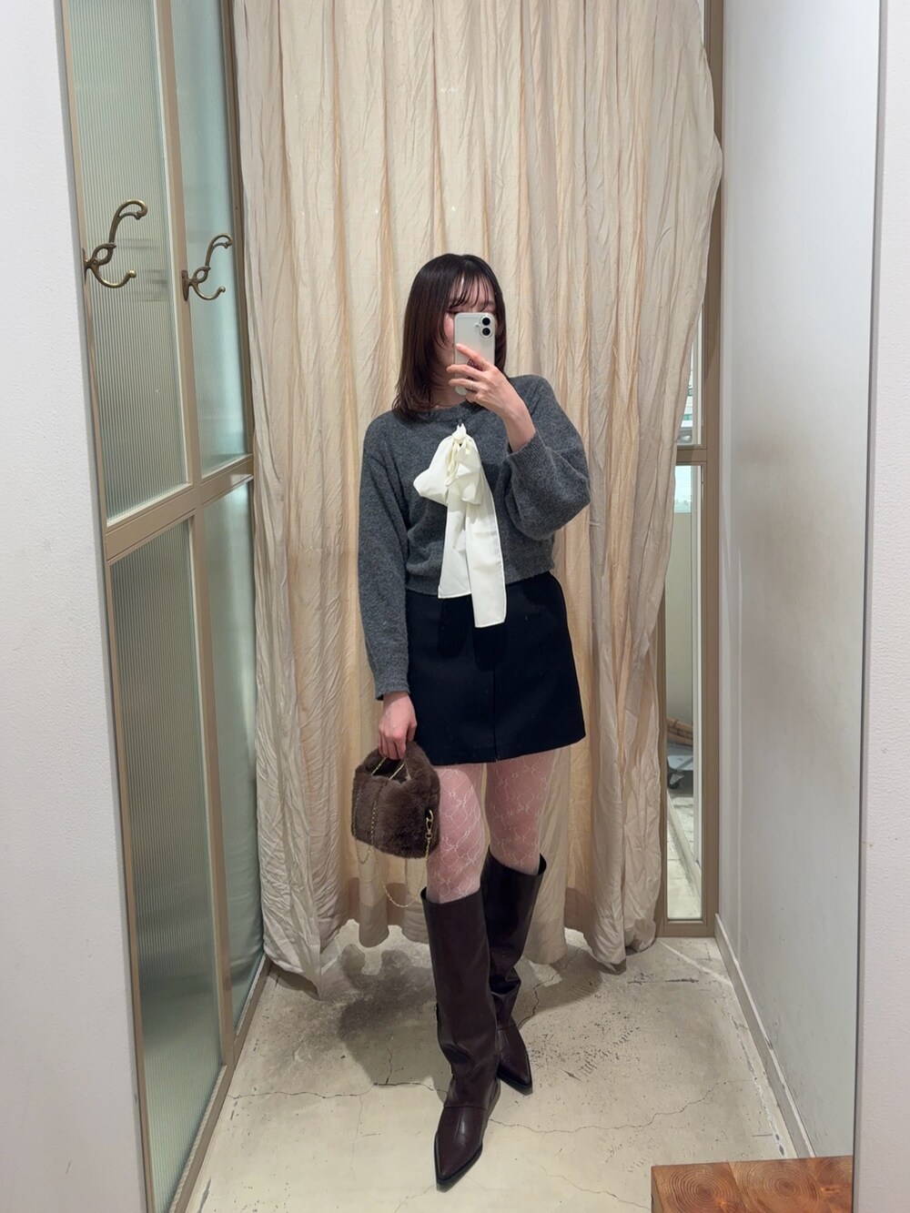 グレー系のニット/セーター、ブルー系のデニムパンツ、ブラウン系のパンプスを着用したレディースの冬コーディネートの4枚目の写真
