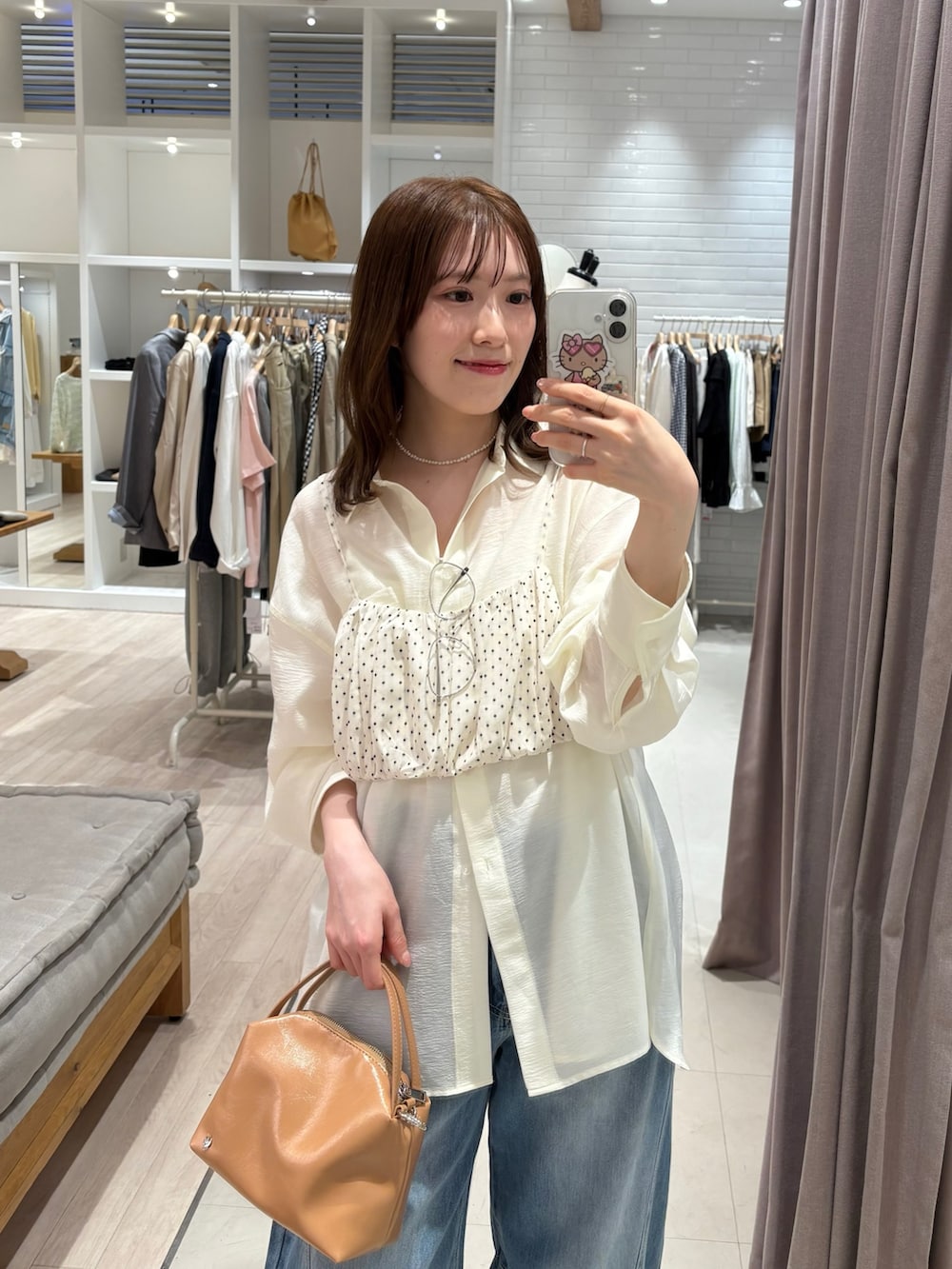 イエロー系のトートバッグ、ホワイト系のキャミソール、ホワイト系のシャツ/ブラウスを着用したレディースの春コーディネートの2枚目の写真