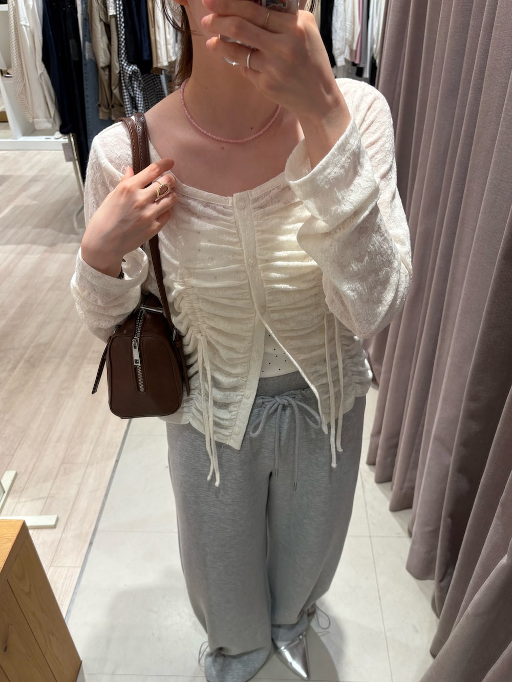 ホワイト系のカーディガン/ボレロ、ホワイト系のキャミソール、グレー系のスウェットパンツを着用したレディースの春コーディネートの3枚目の写真