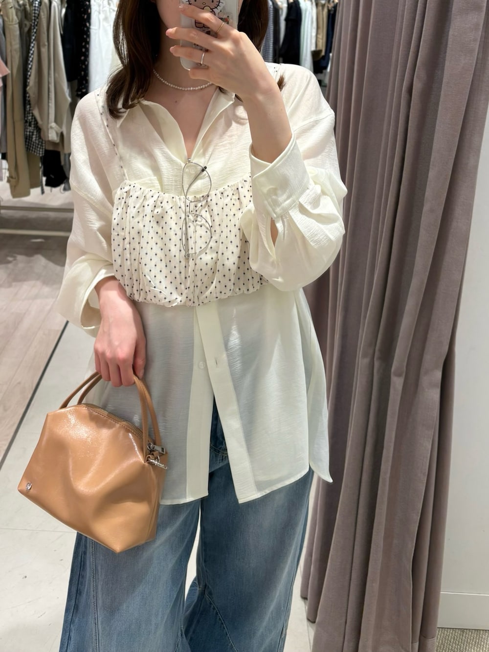 イエロー系のトートバッグ、ホワイト系のキャミソール、ホワイト系のシャツ/ブラウスを着用したレディースの春コーディネートの3枚目の写真