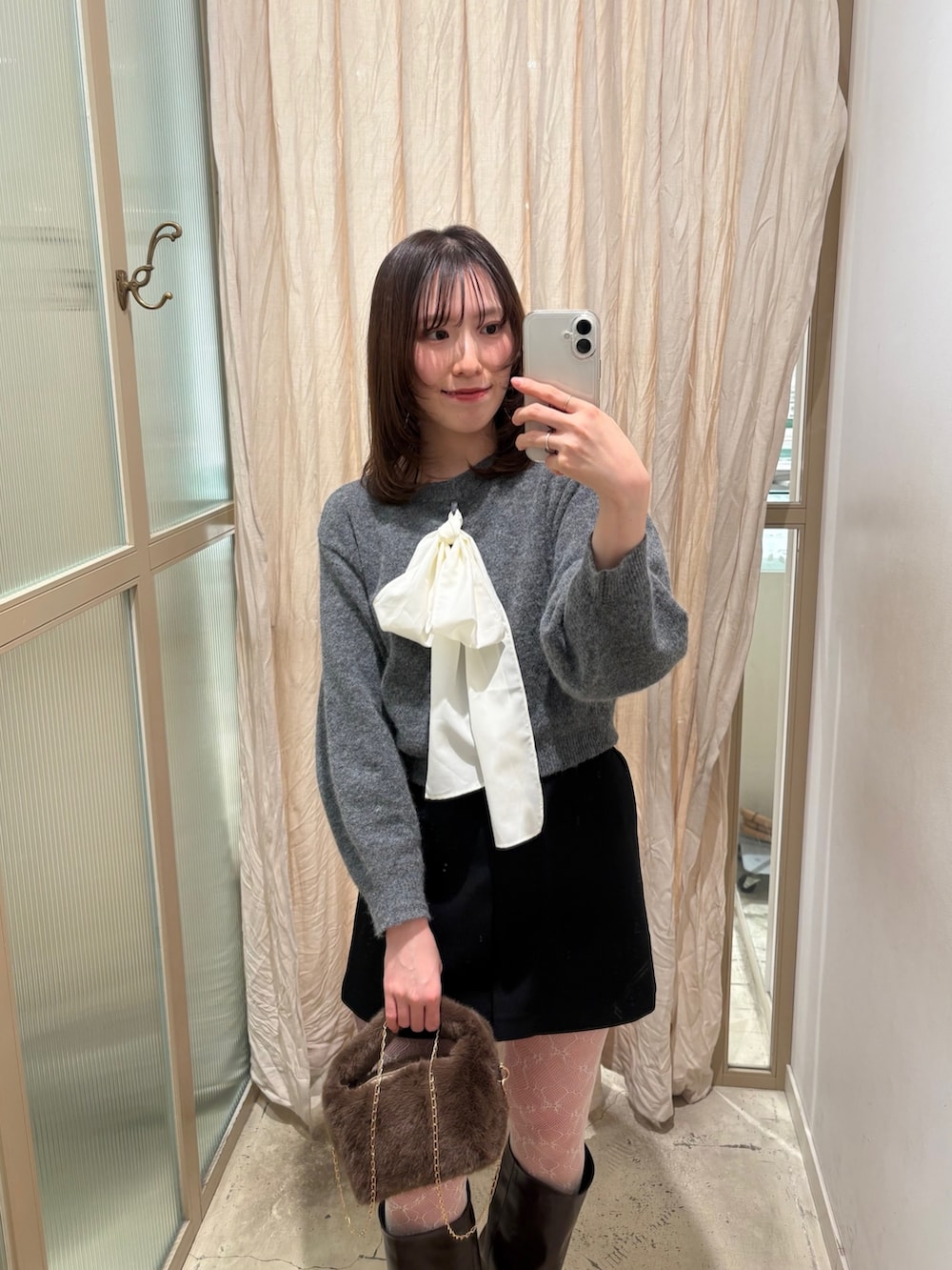 グレー系のニット/セーター、ブルー系のデニムパンツ、ブラウン系のパンプスを着用したレディースの冬コーディネートの3枚目の写真