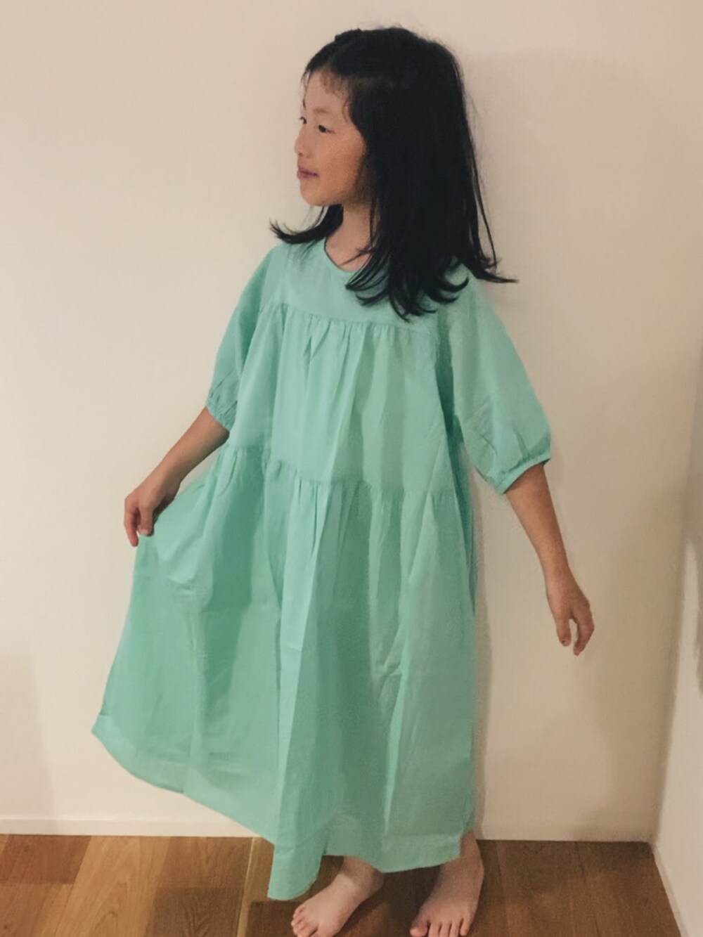 グリーン系のワンピースを着用したレディースの夏コーディネートの3枚目の写真